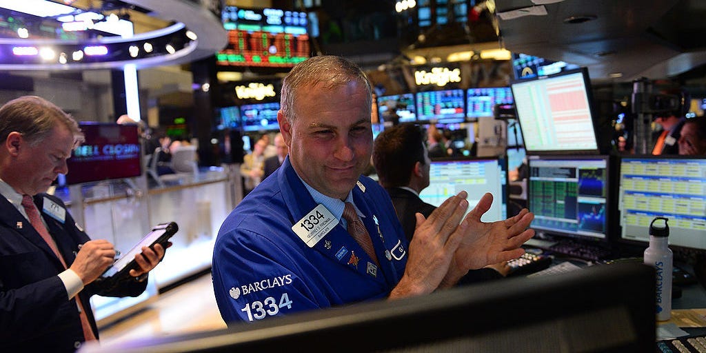 A stock trader claps at the end of trade at the New York Stock Exchange