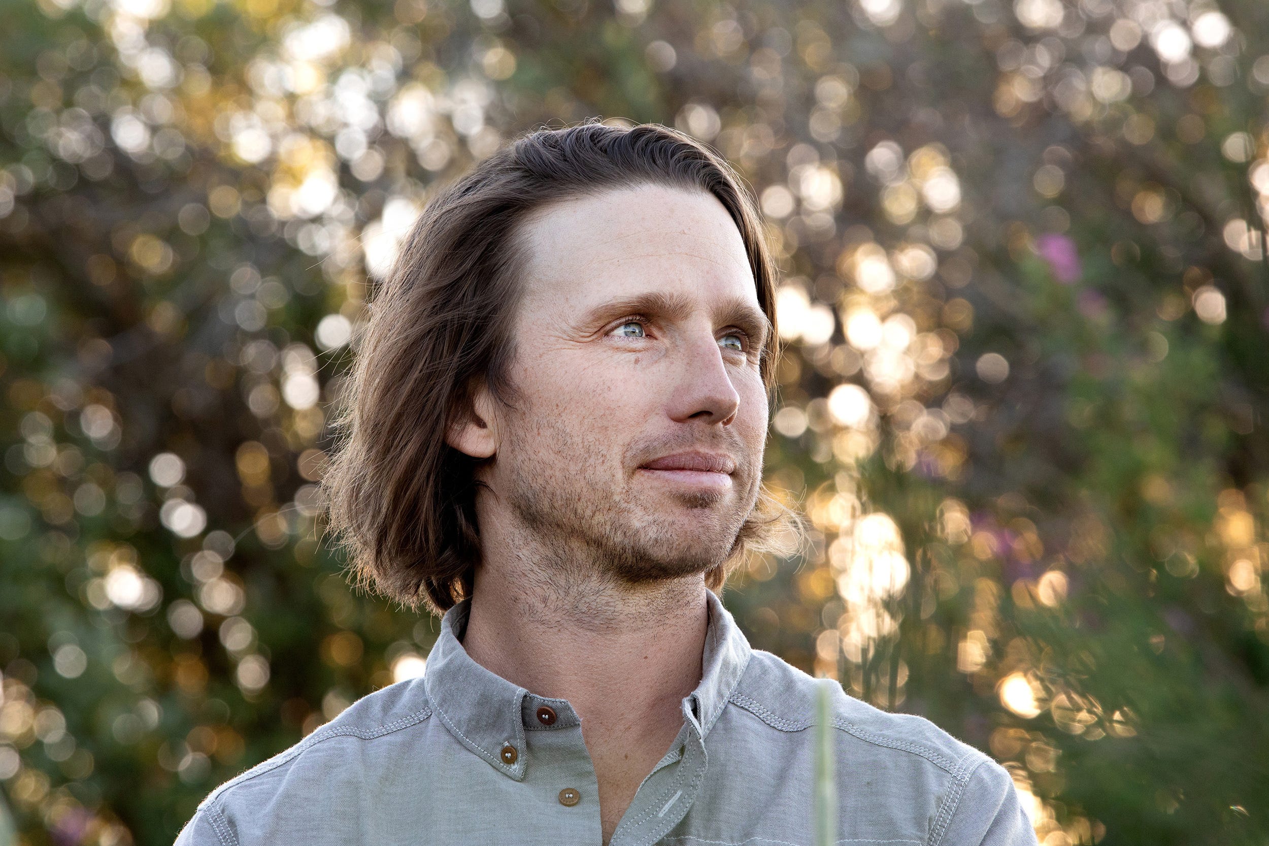 Charles Post looks off to the side while posing outside in a gray collared shirt.