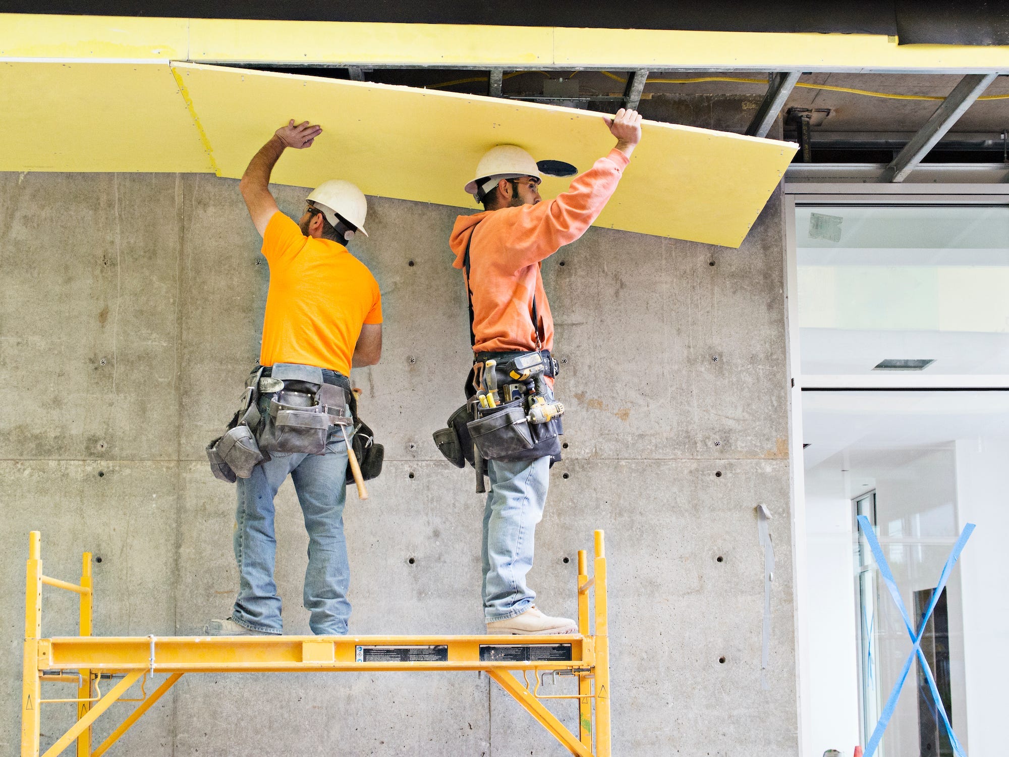 Construction workers applying insulation