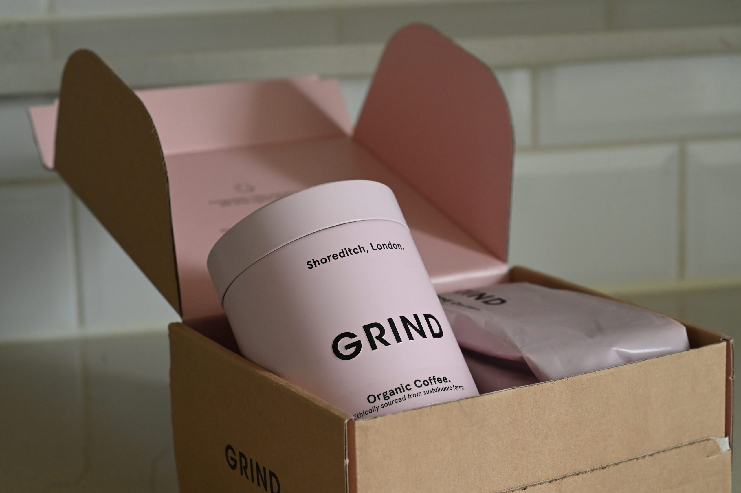 A pink coffee tin in a package from Grind Coffee in London