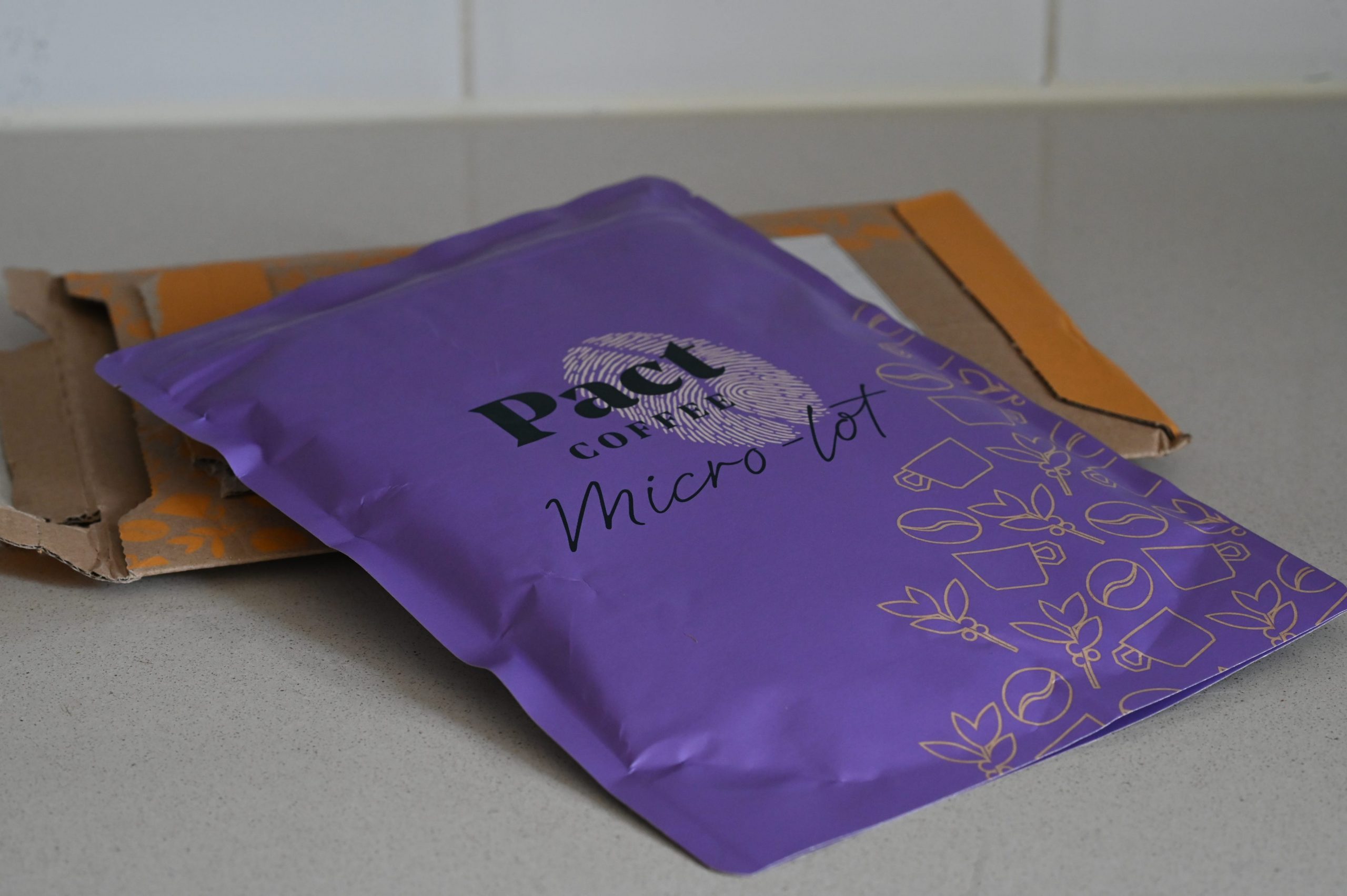 A purple bag of Pact Micro-lot coffee on a gray kitchen counter