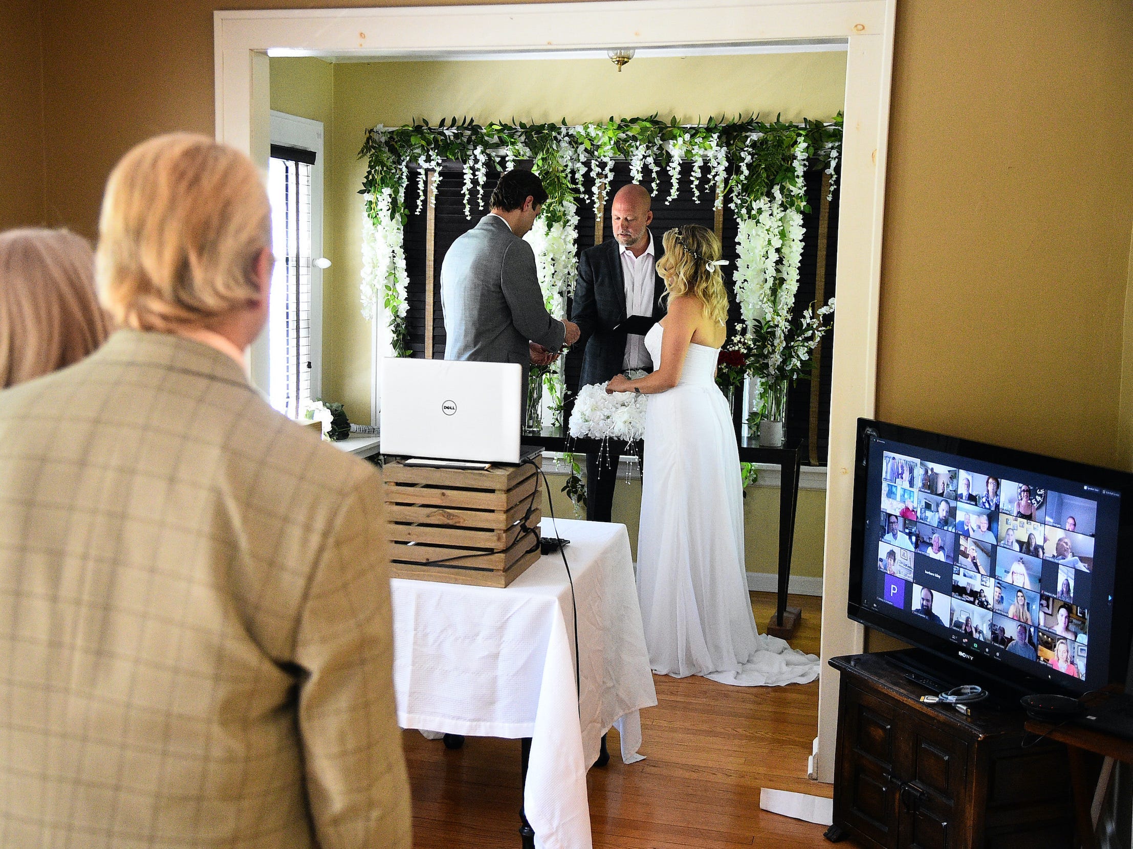 Bride and groom exchange vows with guests watching over Zoom