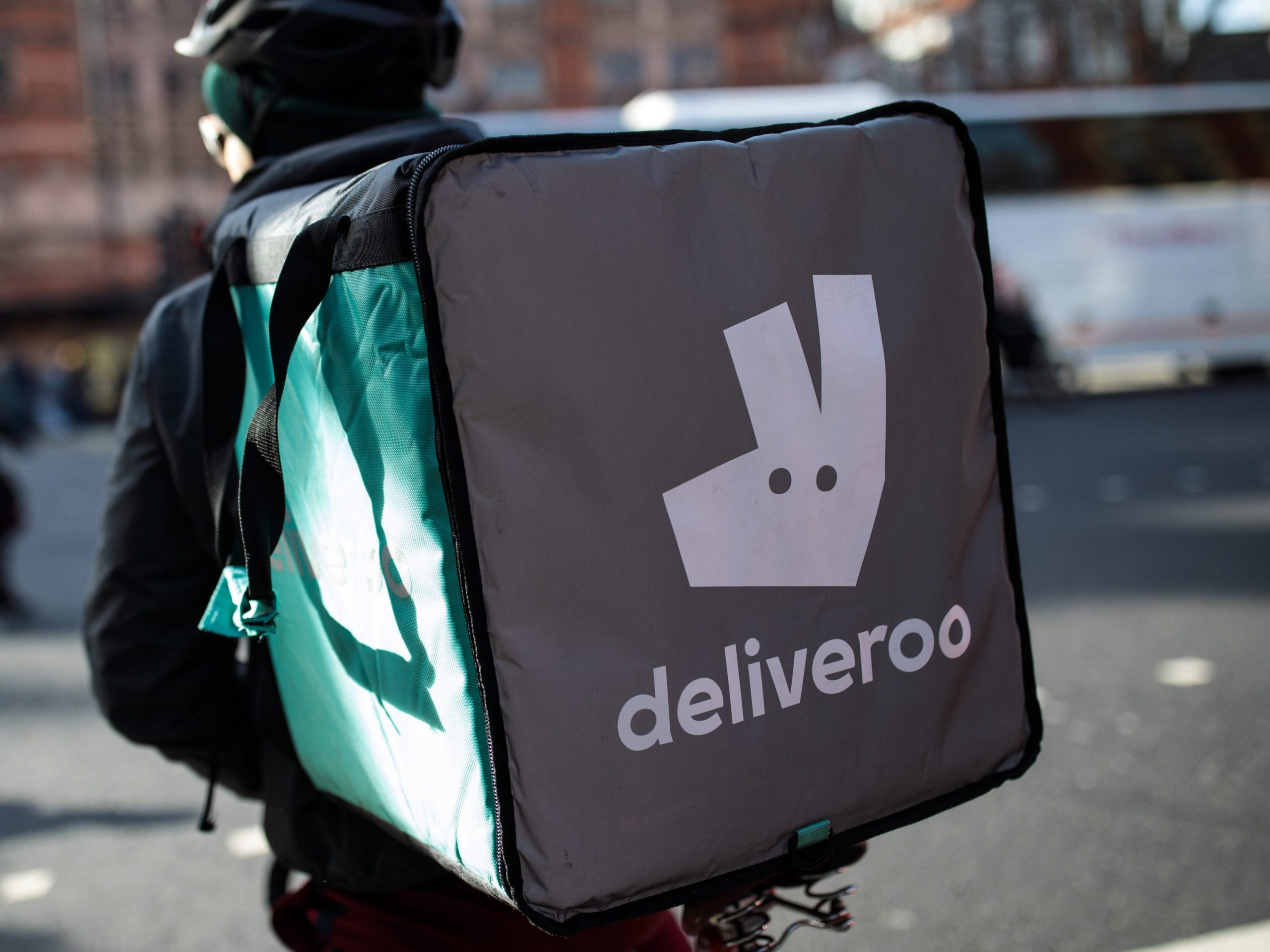 A Deliveroo rider cycles through central London