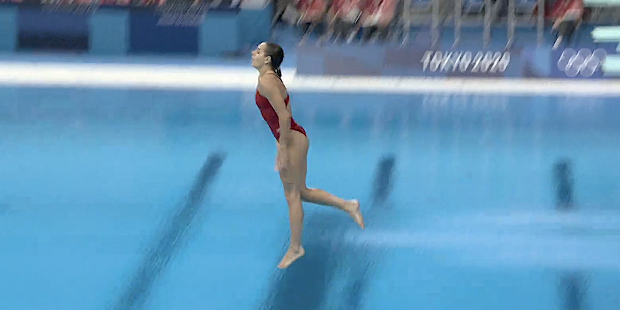 Screenshot shows Pamela Ware going feet first into the pool on a dive attempt at the Tokyo Olympics.