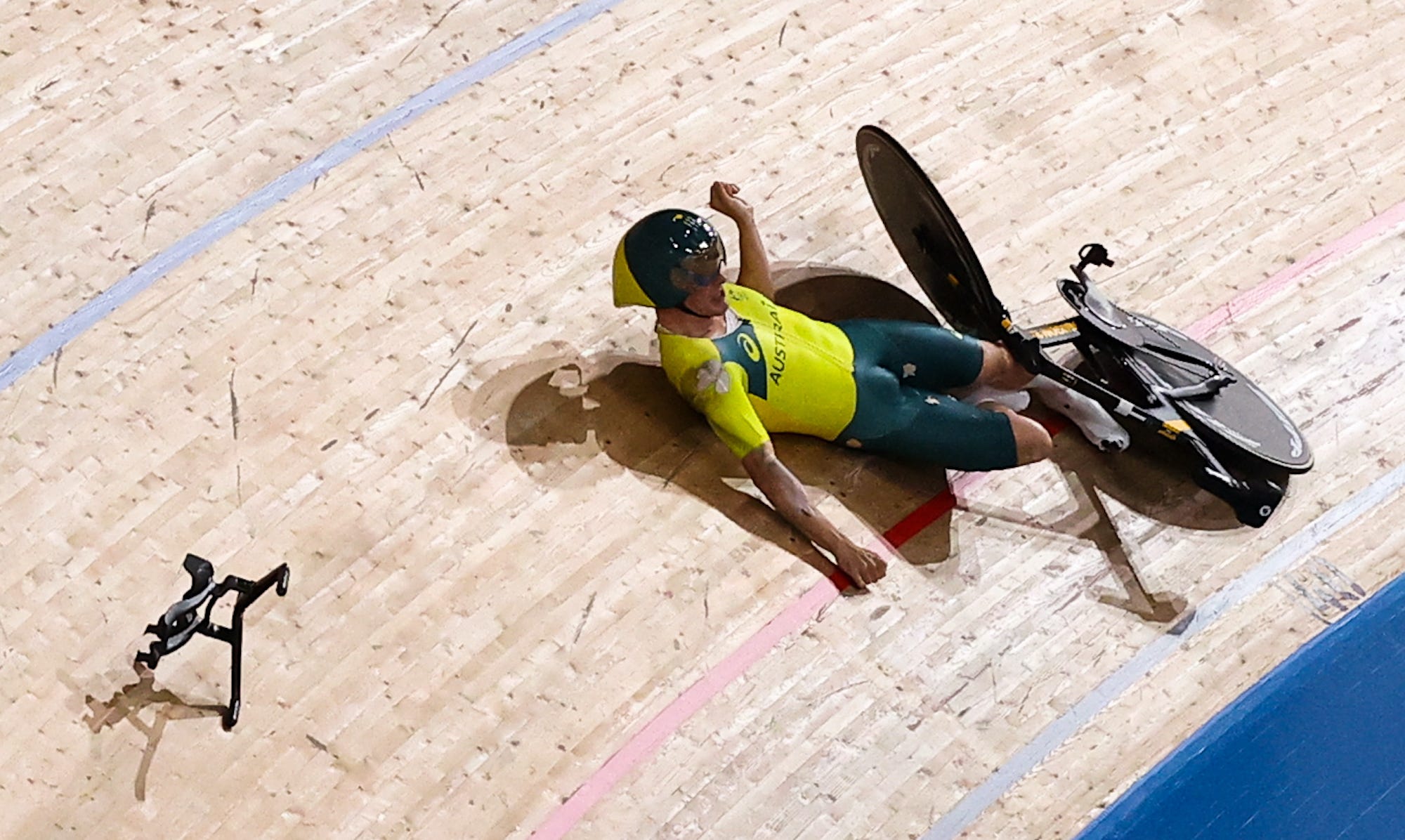 Alexander Porter lying on the track with his bike, and his handlebars far away from him