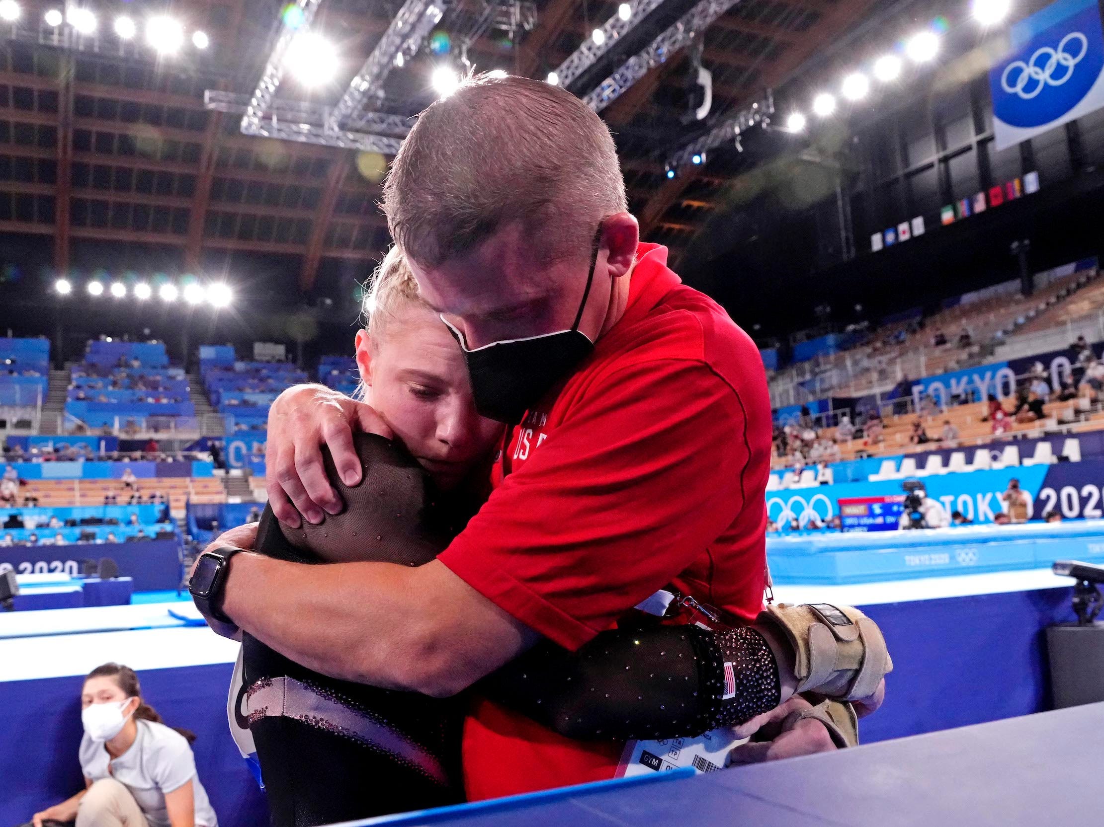 Brian Carey (right) - Jade Carey's father and coach - comforts his daughter after her vault mishap.