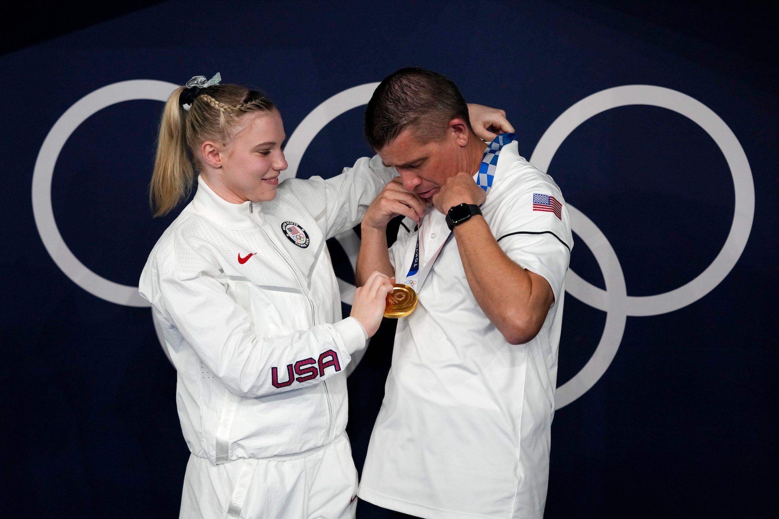 Jade Carey places her gold medal around her father's neck.