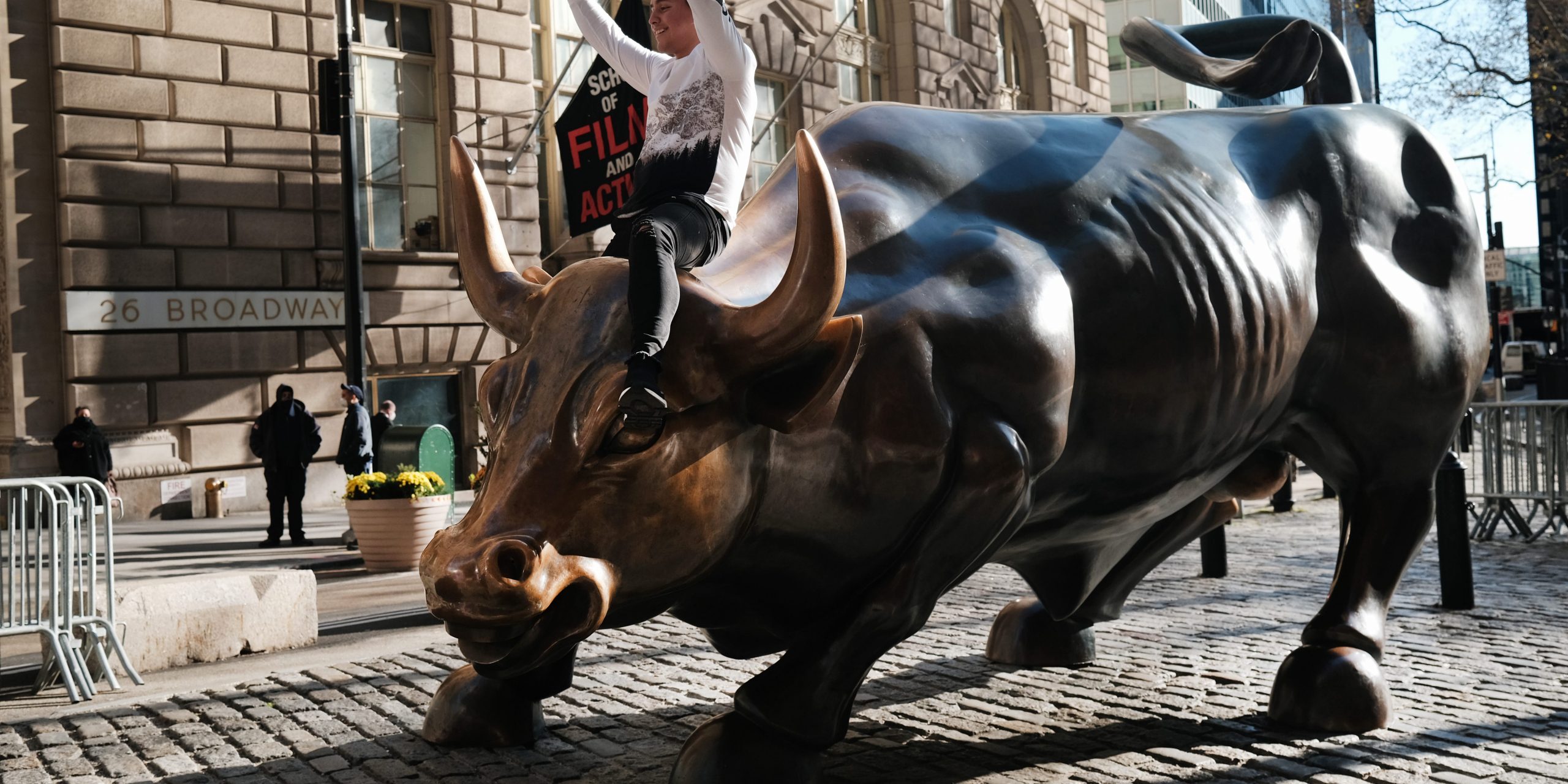 A man sits on the Wall street bull near the New York Stock Exchange