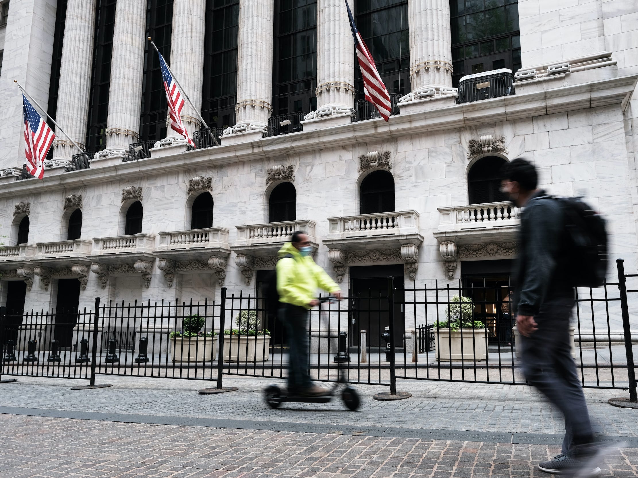 Men pass the New York Stock Exchange on Wall Street