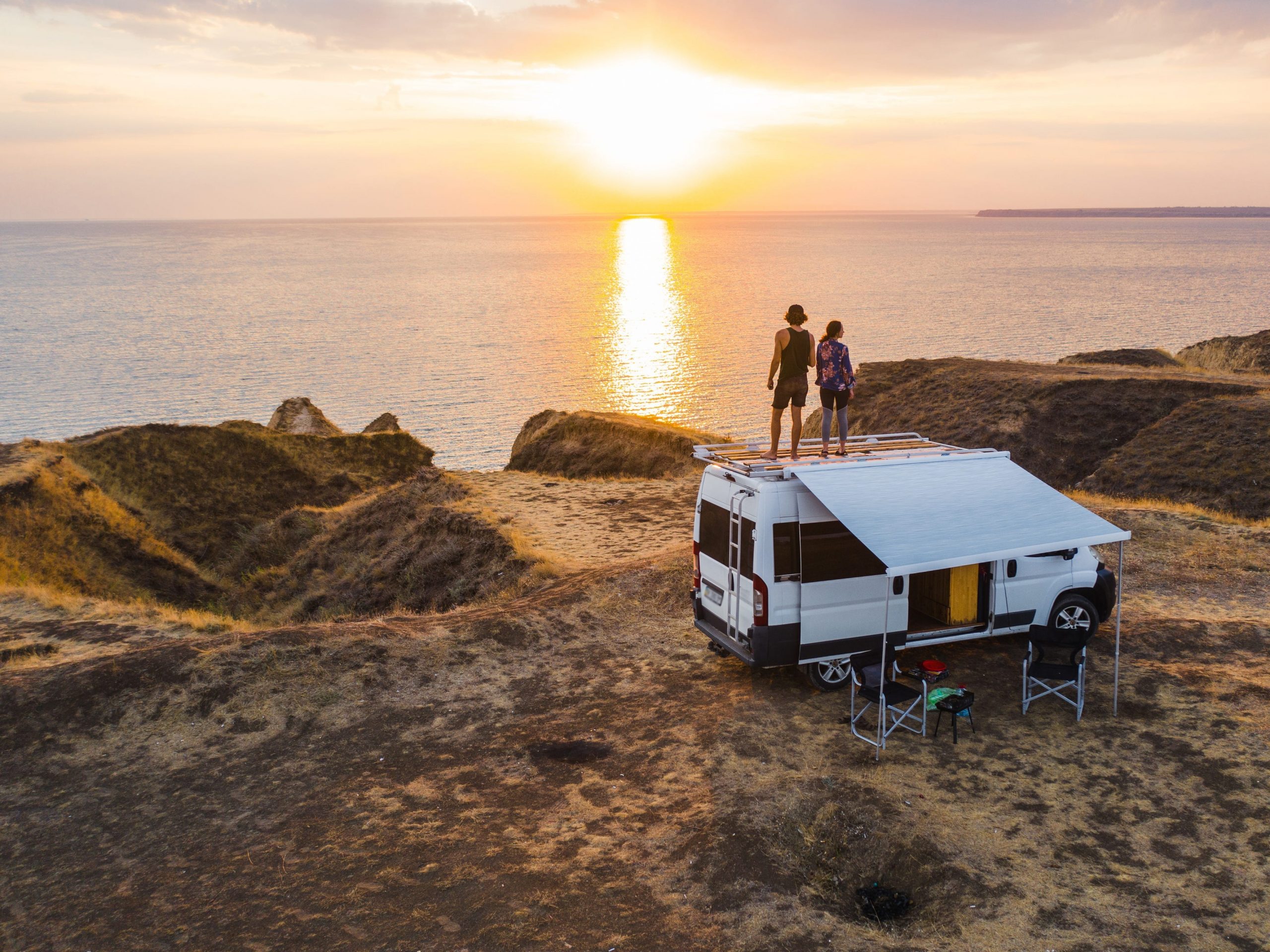 Heterosexual couple standing on van