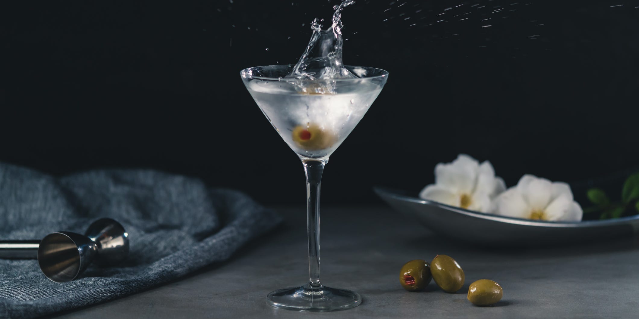 An olive splashing into a chilled martini