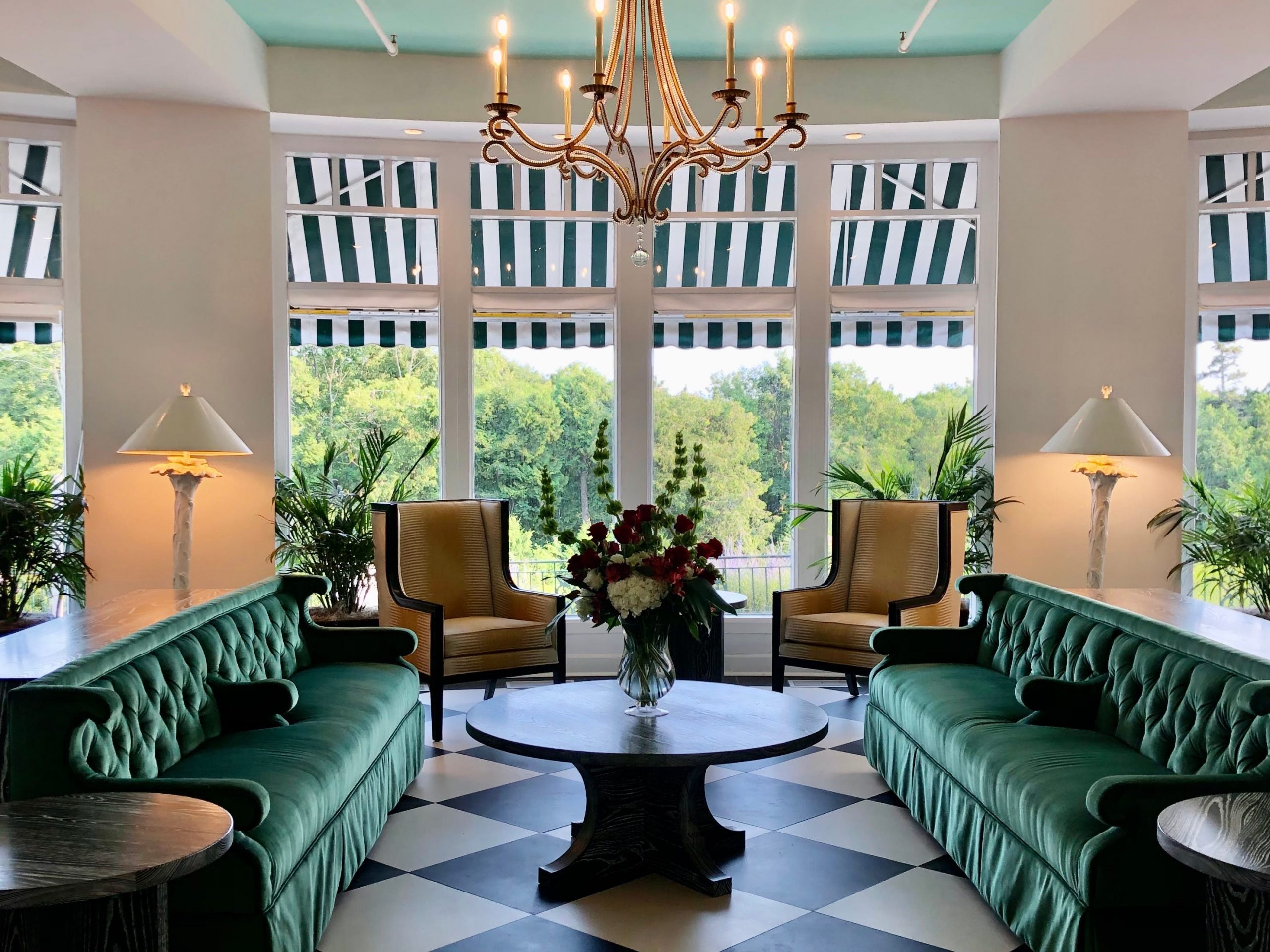 Grand Hotel's interior with chandeliers, checkered floors and green velvet couches