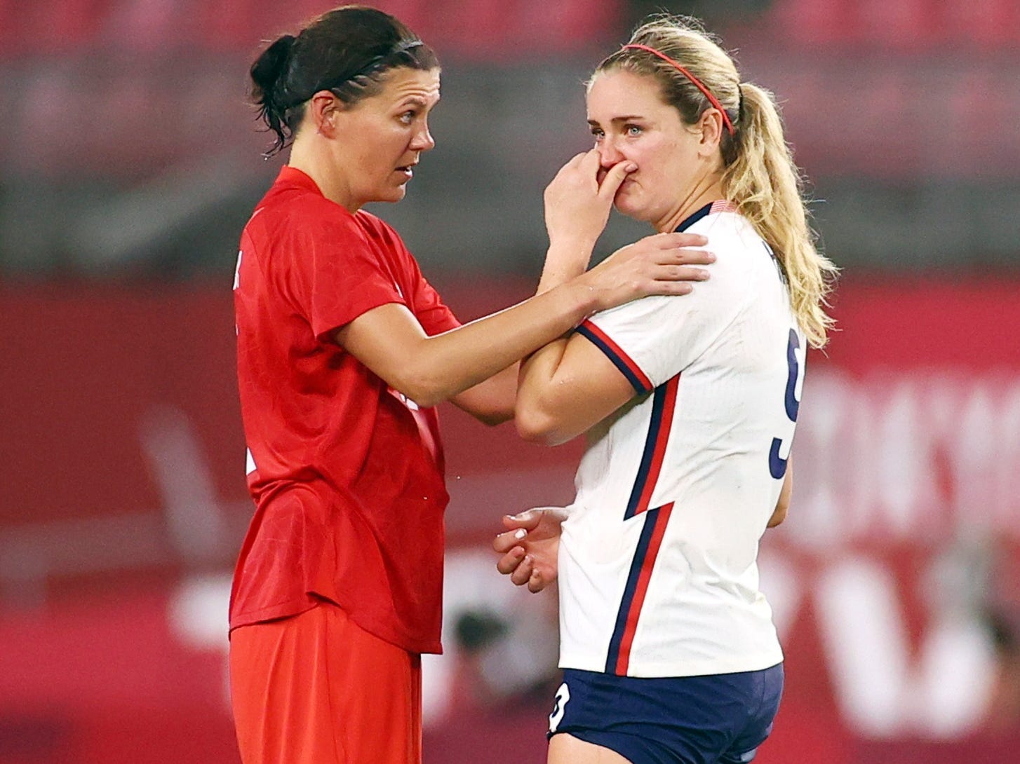 Christine Sinclair comforts Lindsey Horan.