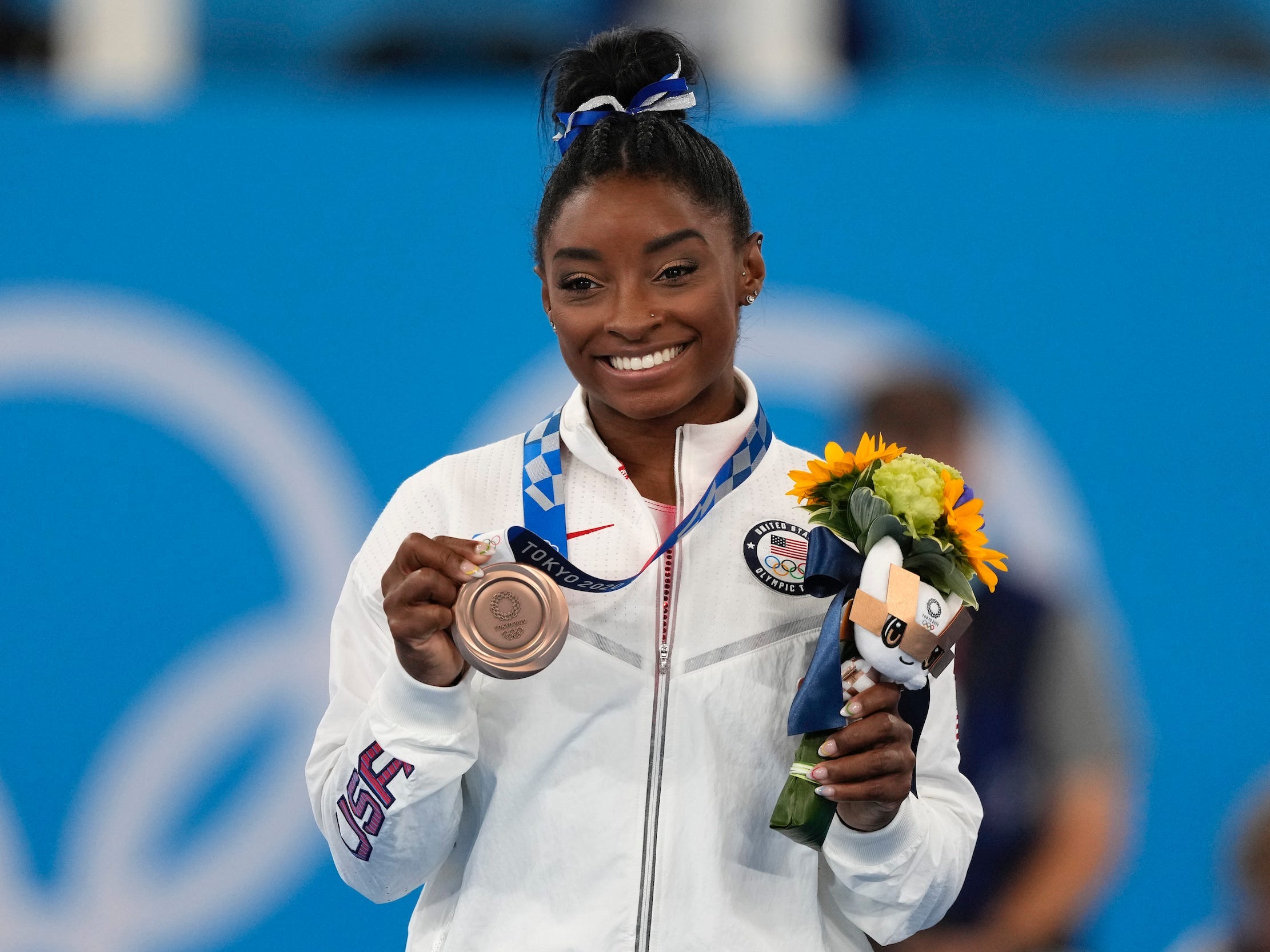 Simone Biles posing with her bronze medal from the balance beam in Tokyo.