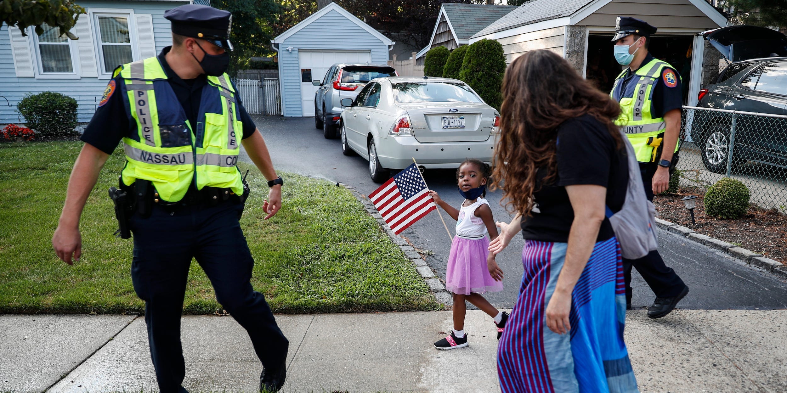 This photo from Monday July 13, 2020, shows Nassau County Police officers walk alongside protesters participating in a Black Lives Matter march through a residential neighborhood calling for racial justice in Valley Stream, N.Y