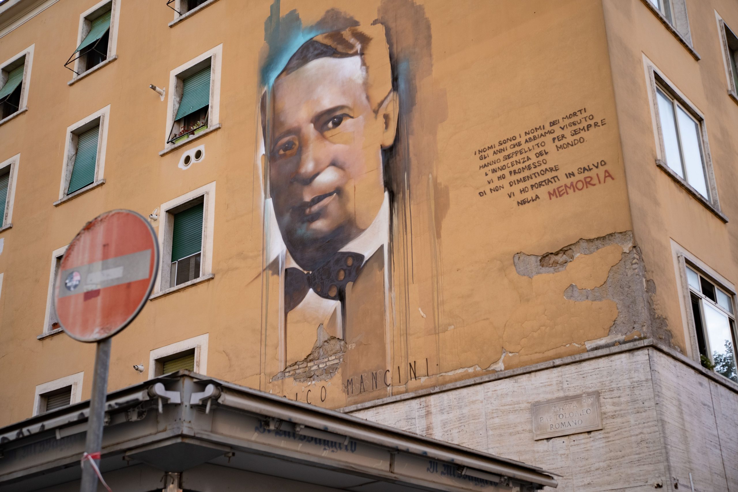 A man's face is painted onto the facade of a building.