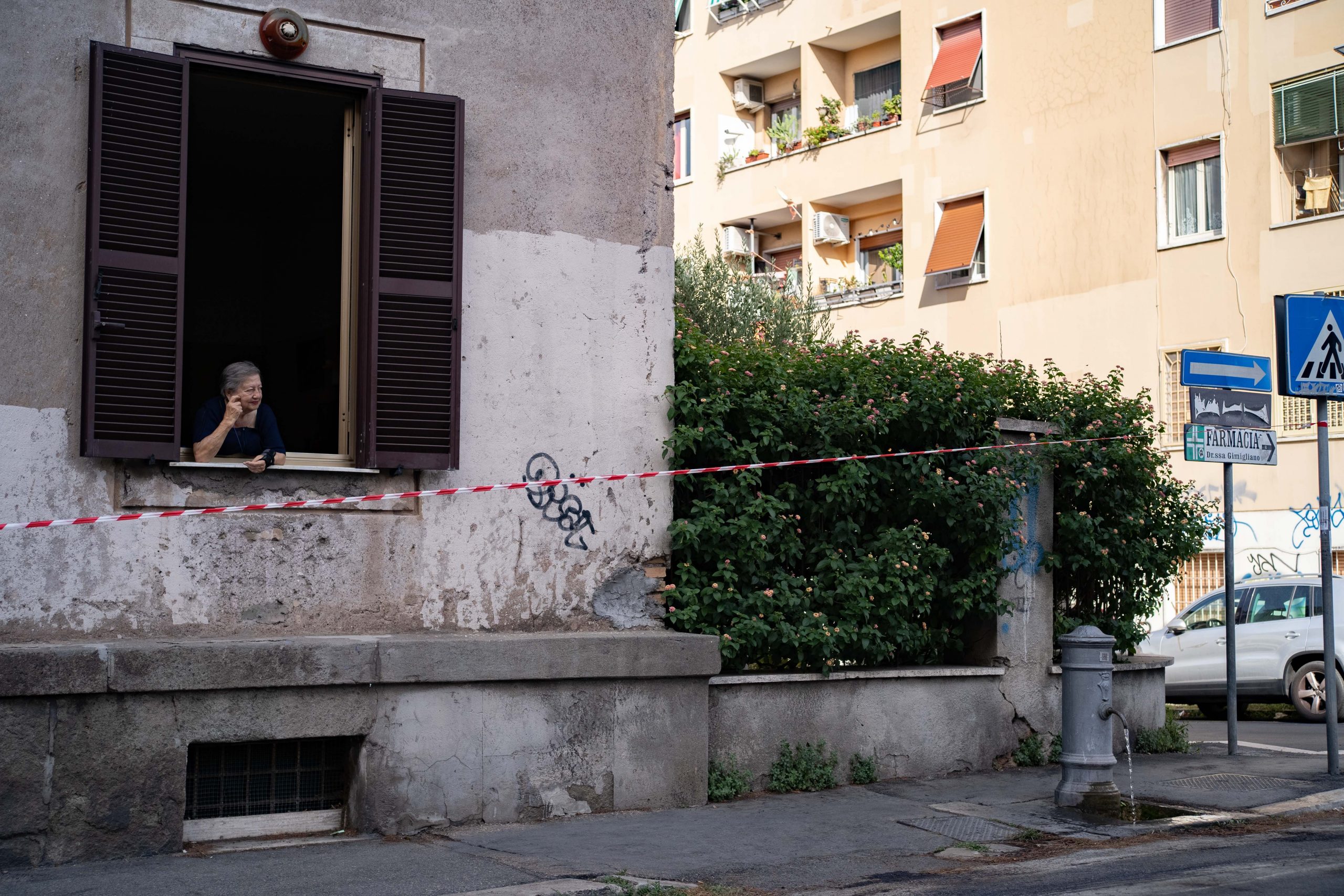 A woman is seen at her window alongside a street.