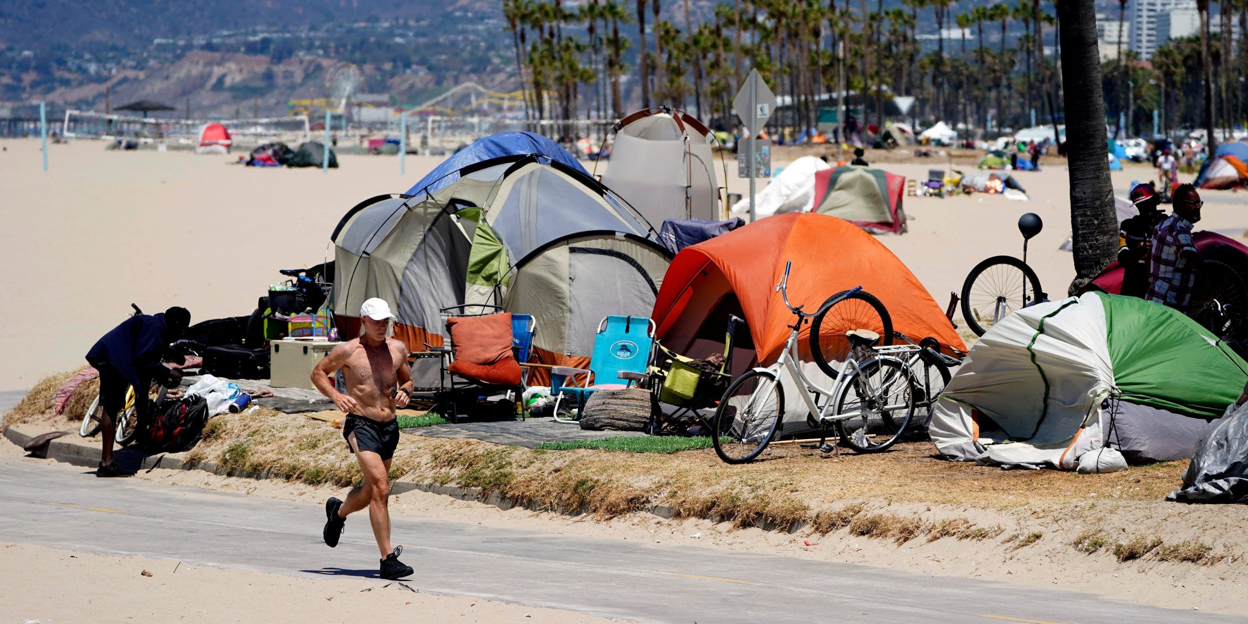 A person jogs pass homeless encampment on Venice Beach