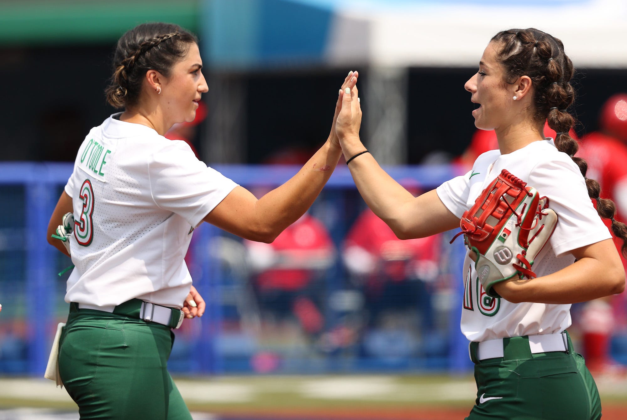 Danielle O'Toole and Tatyana Forbes of Team Mexico high five after the fourth inning of their game against Team Japan during the Softball Opening Round of the Tokyo 2020 Olympic Games at Fukushima Azuma Baseball Stadium