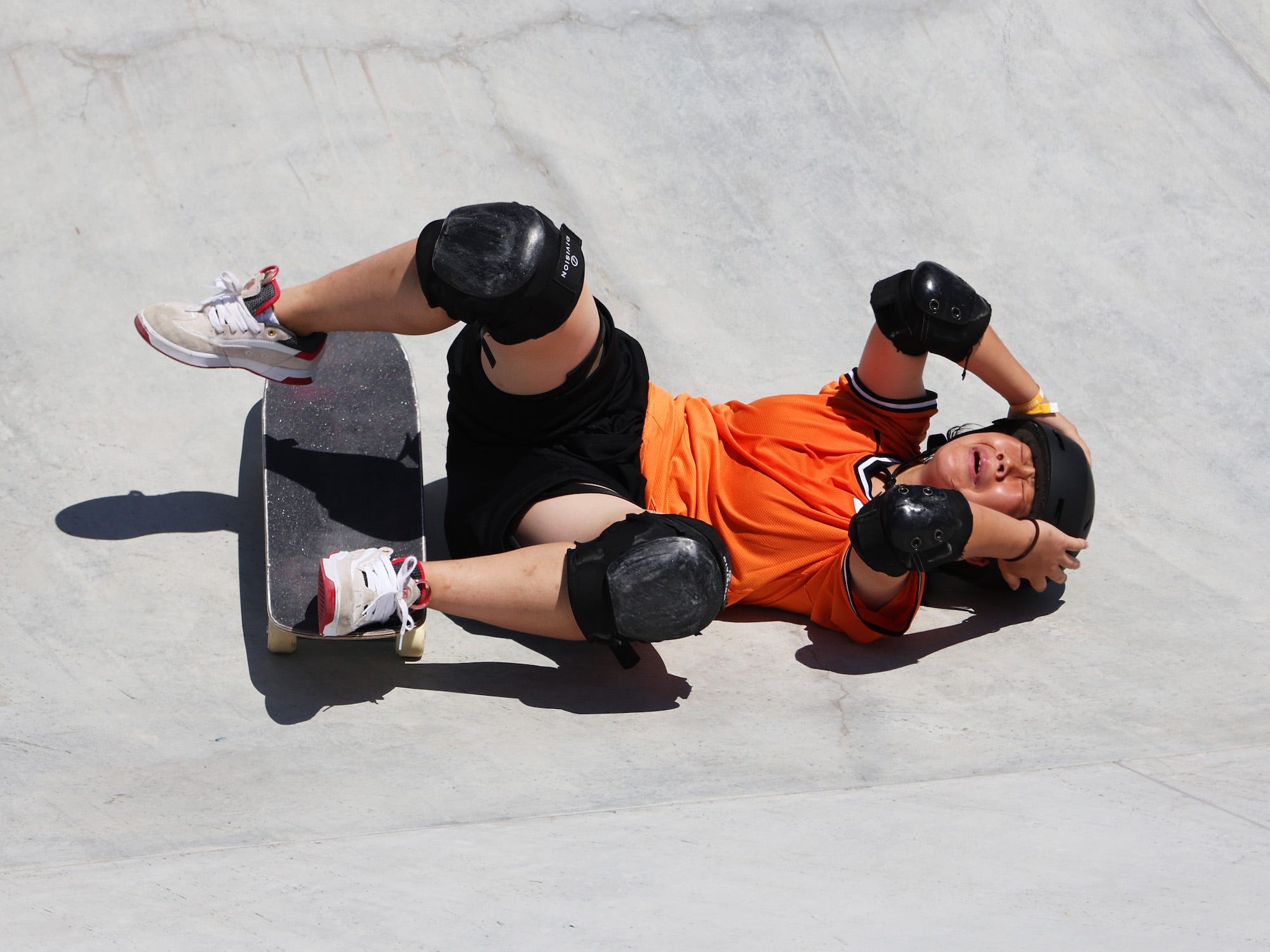 Misugu Okamoto holds her helmet after falling during the skateboarding event at the Tokyo Olympics.