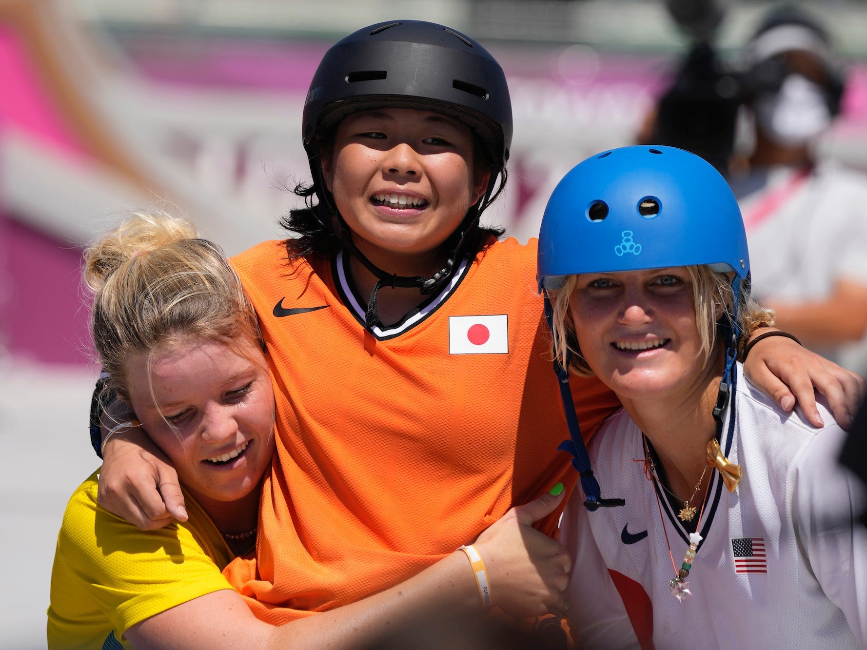 Misugu Okamoto (middle) is greeted by two other skaters at the Tokyo Olympics.