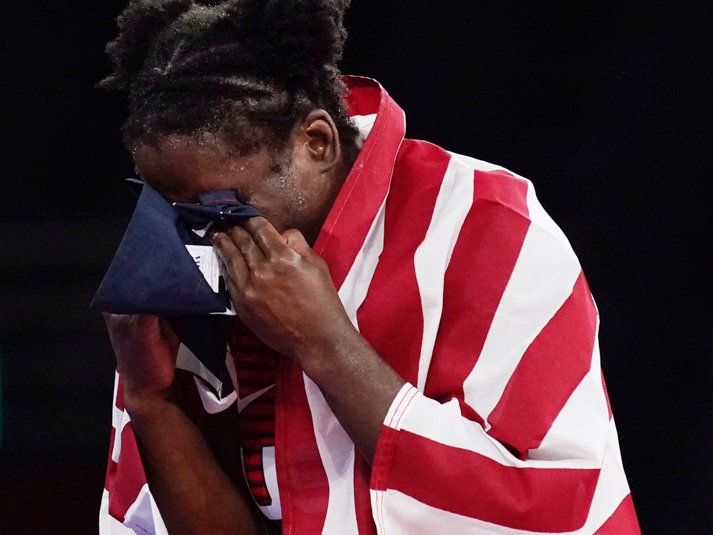 Tamyra Mensah-Stock cries into an American flag after winning Olympic gold.