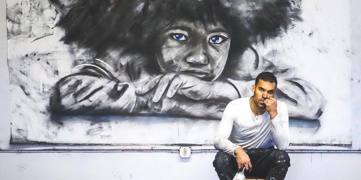 Micah Johnson sits in front of a charcoal artwork.
