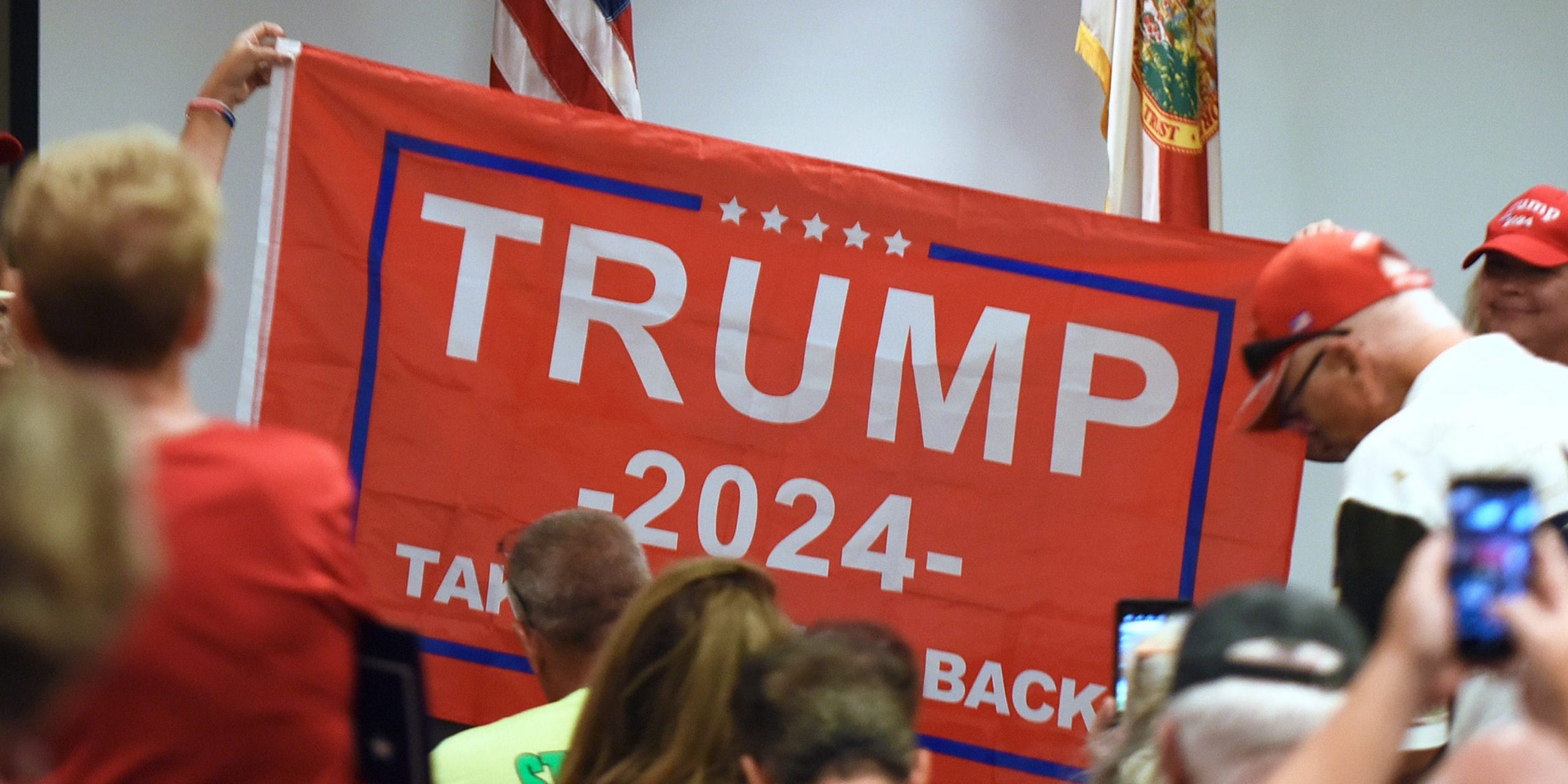 People hold a Trump 2024 flag before U.S. Rep. Matt Gaetz (R-FL) who arrives to address supporters at a Matt Gaetz Florida Man Freedom Tour event at the Hilton Melbourne Beach on July 31, 2021.