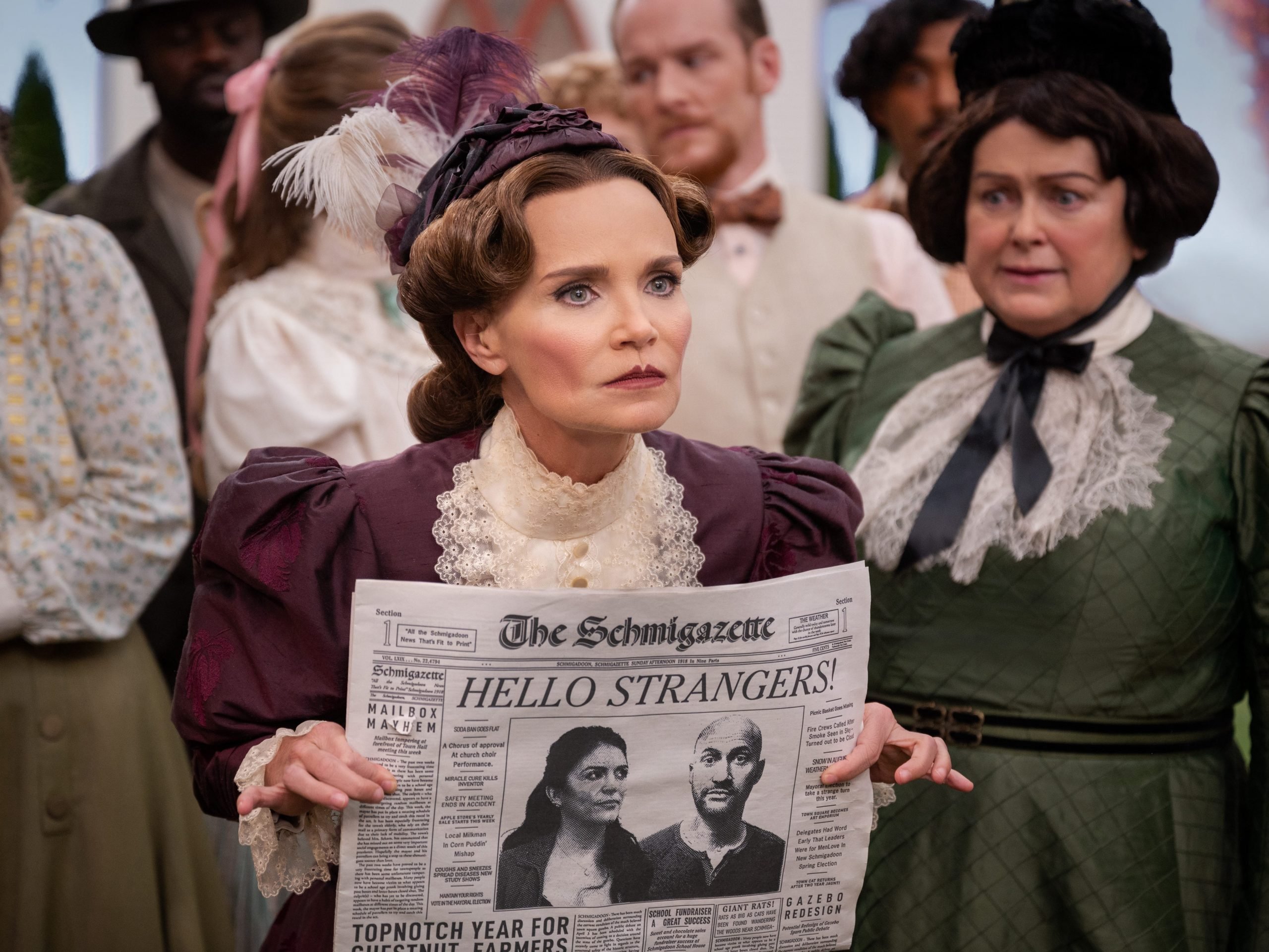 Schmigadoon Kristin Chenoweth shows newspaper to crowd