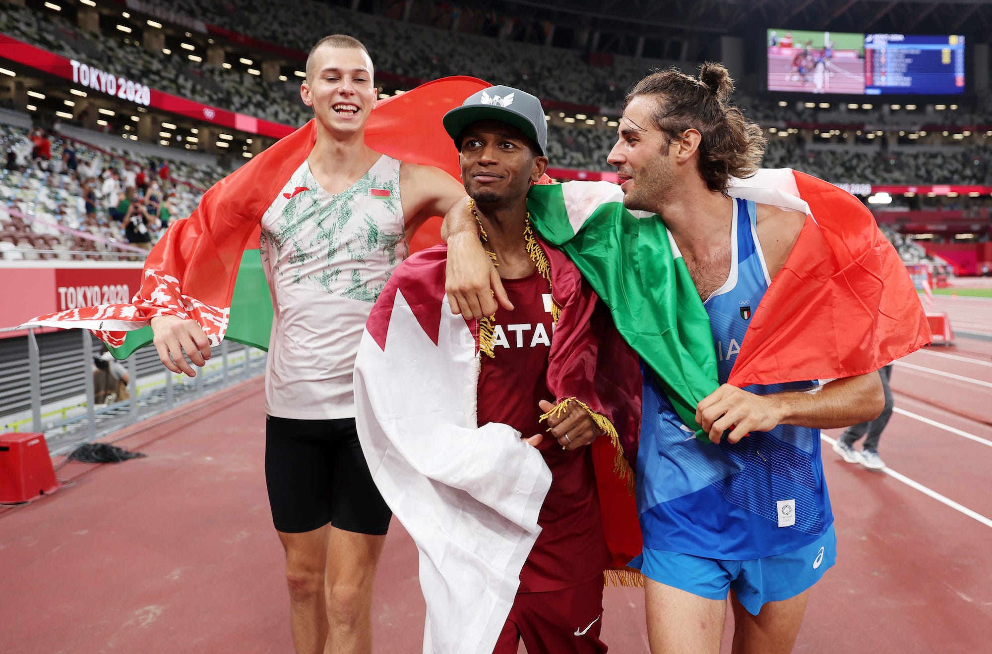 Bronze medalist Maksim Nedasekau of Team Belarus, Gold medalist Mutaz Essa Barshim of Team Qatar and silver medalist Gianmarco Tamberi of Team Italy celebrate on the track following the Men's High Jump Final