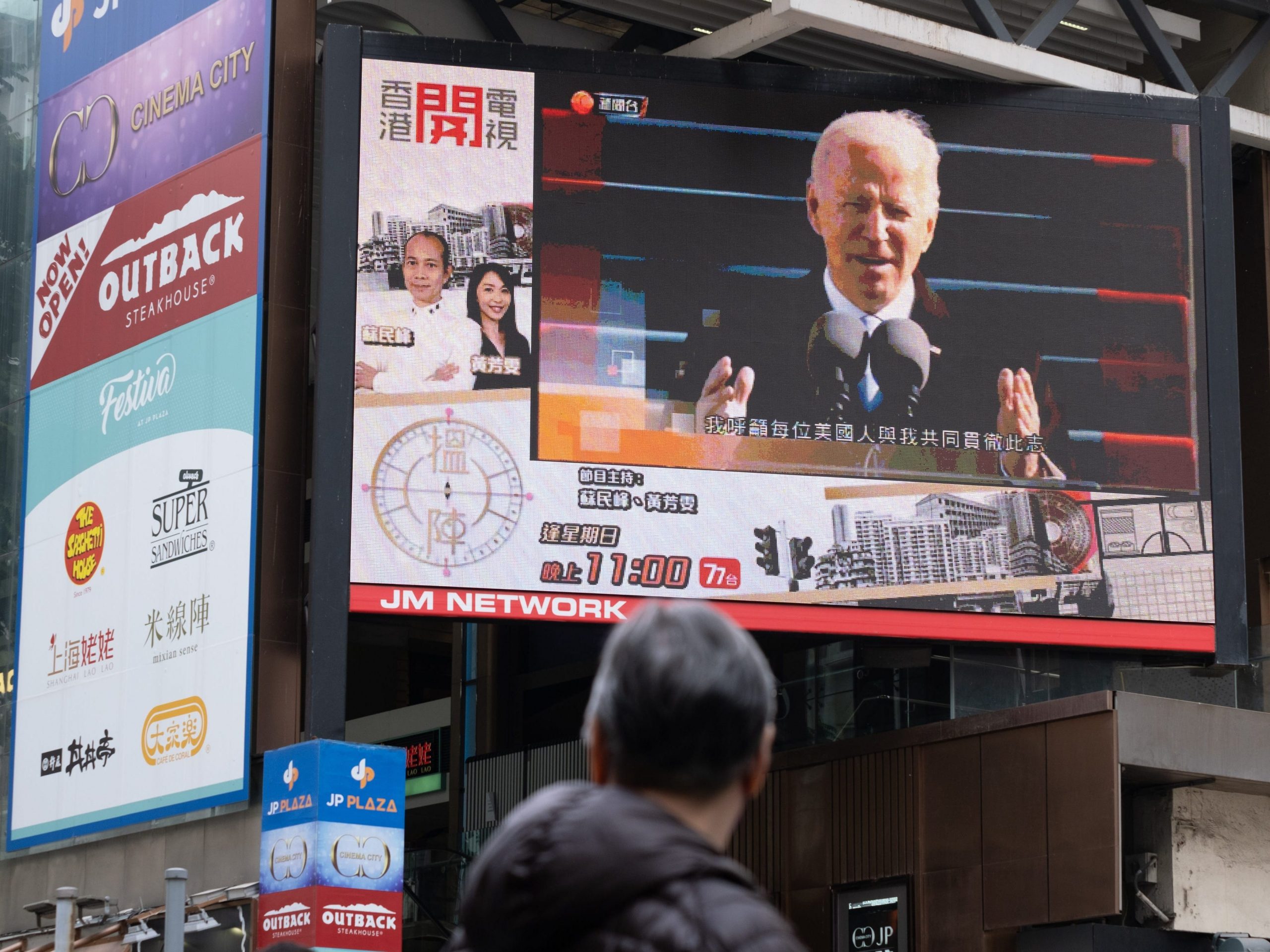 A man is seen watching the news report of the inauguration of President Biden on a large screen in Hong Kong on January 21st, 2021.