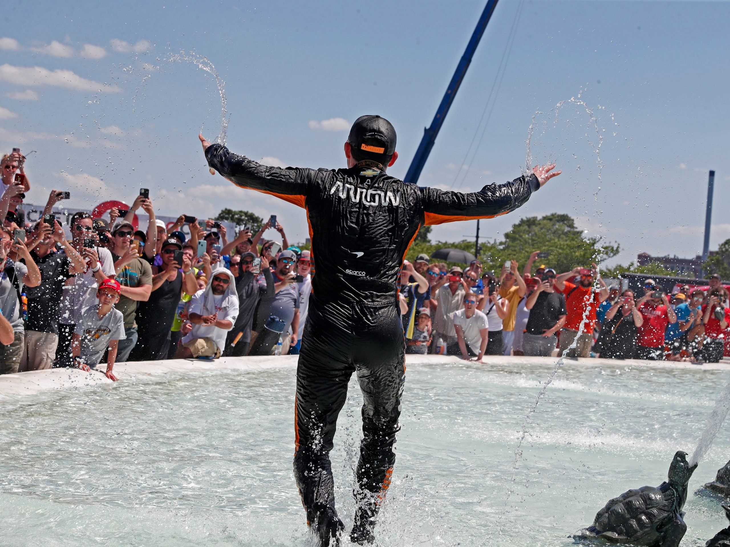 Indy Car series driver Pato O'Ward runs in the James Scott Memorial fountain after winning the Chevrolet Detroit Grand Prix Race 2