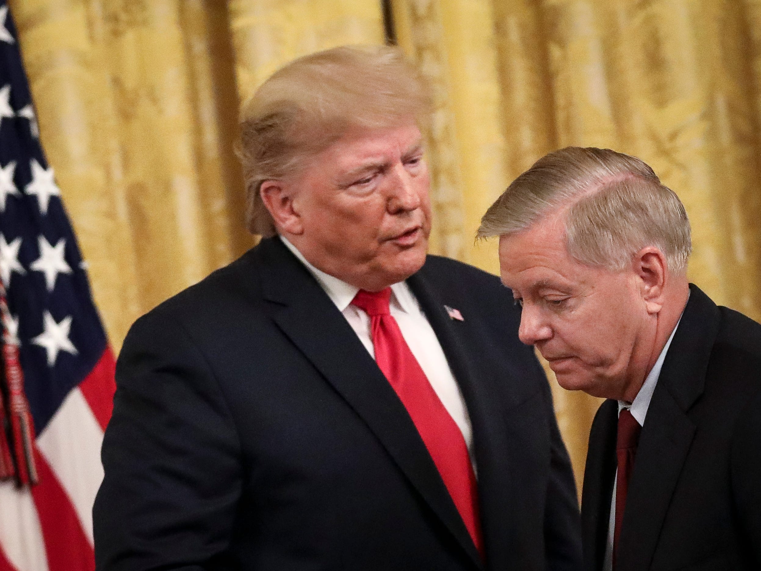 Former President Donald Trump speaks to Sen. Lindsey Graham (R-SC) during an event in the East Room of the White House on November 6, 2019.