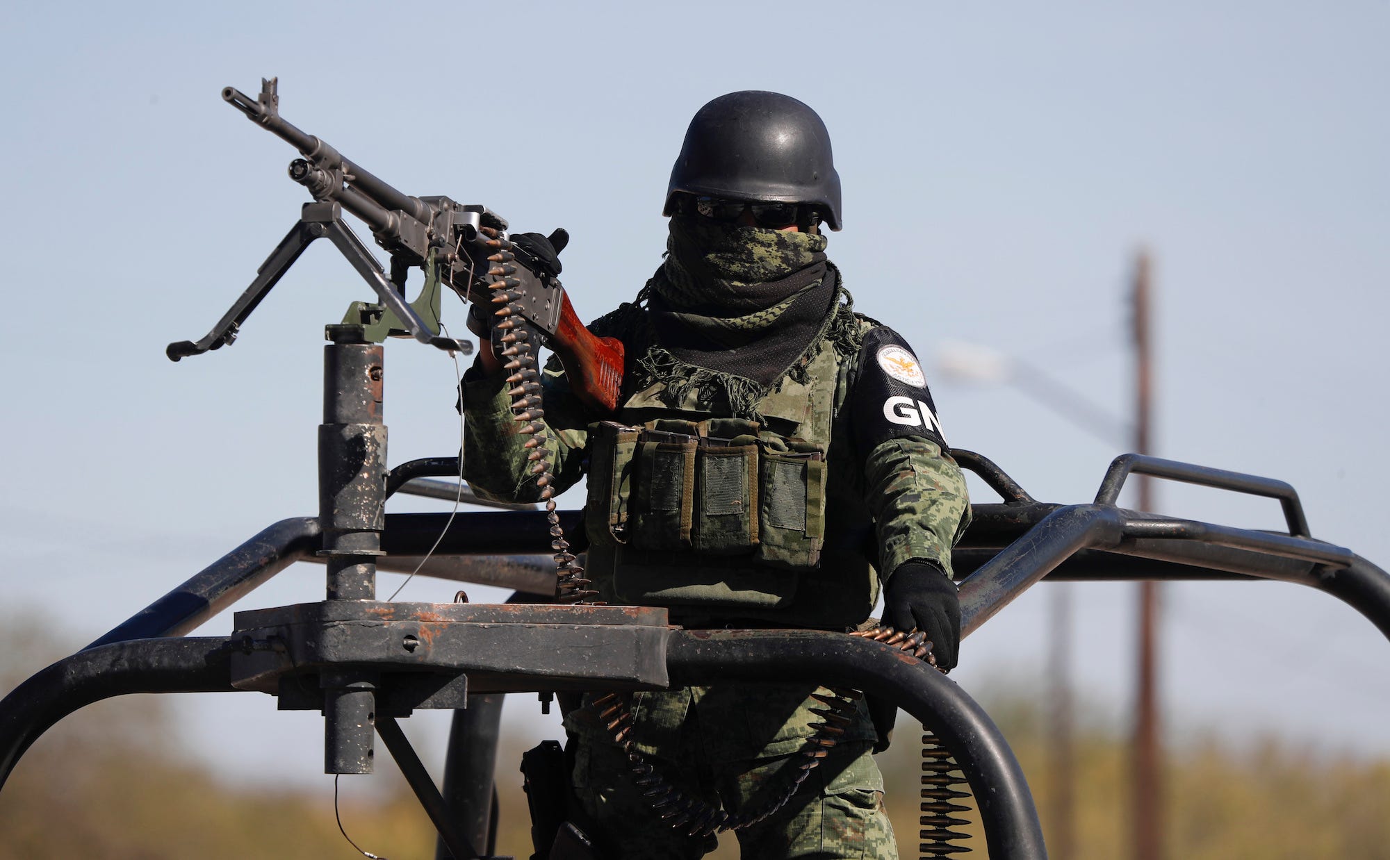 Mexican soldiers police standing guard with a machine gun