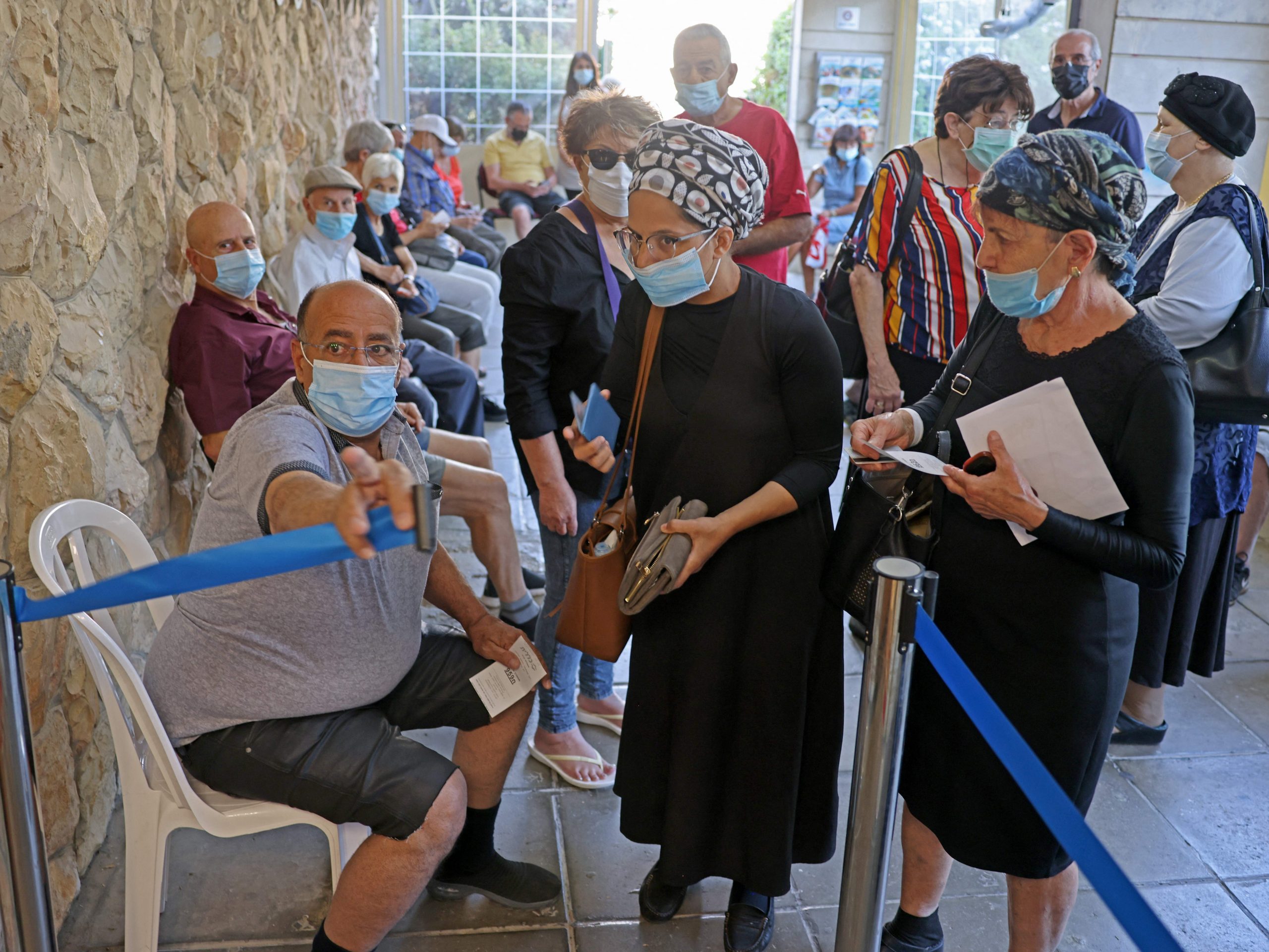 Israelis arrive to get their third dose of the Pfizer-BioNtech COVID-19 vaccine at the Clalit Health Service in Jerusalem on August 1, 2021, as Israel launches its campaign to give booster shots to people aged over 60.