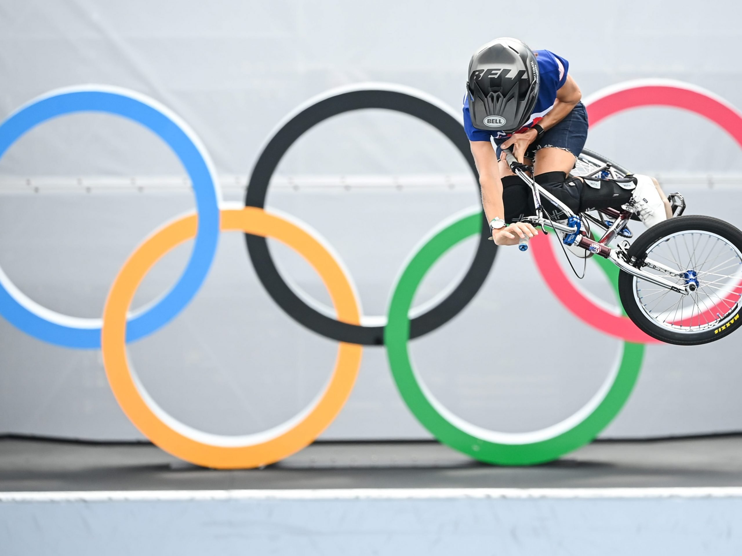 Chelsea Wolfe from the USA jumps in front of the Olympic rings.