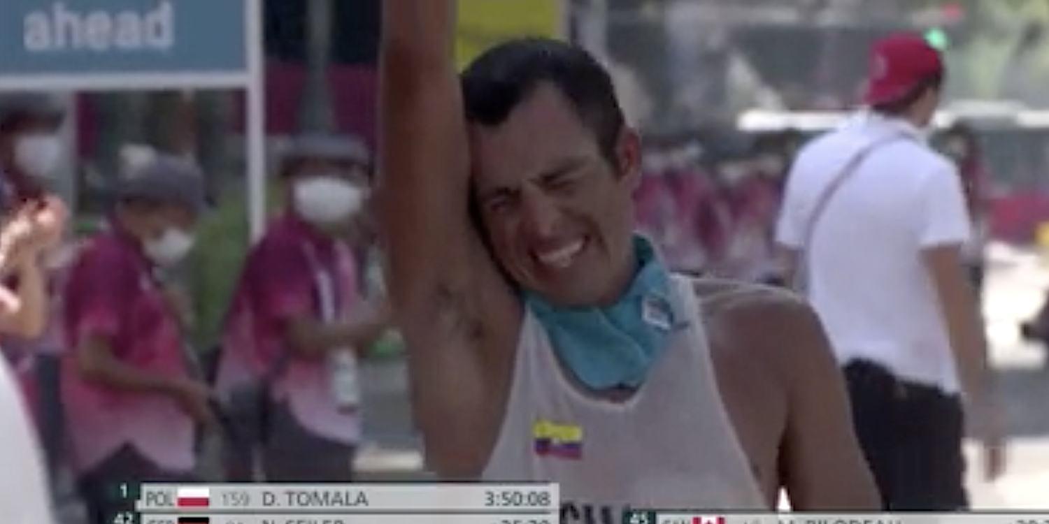 Claudio Villanueva Flores raises his hand after finishing the 50km race walk at the Tokyo Olympics.