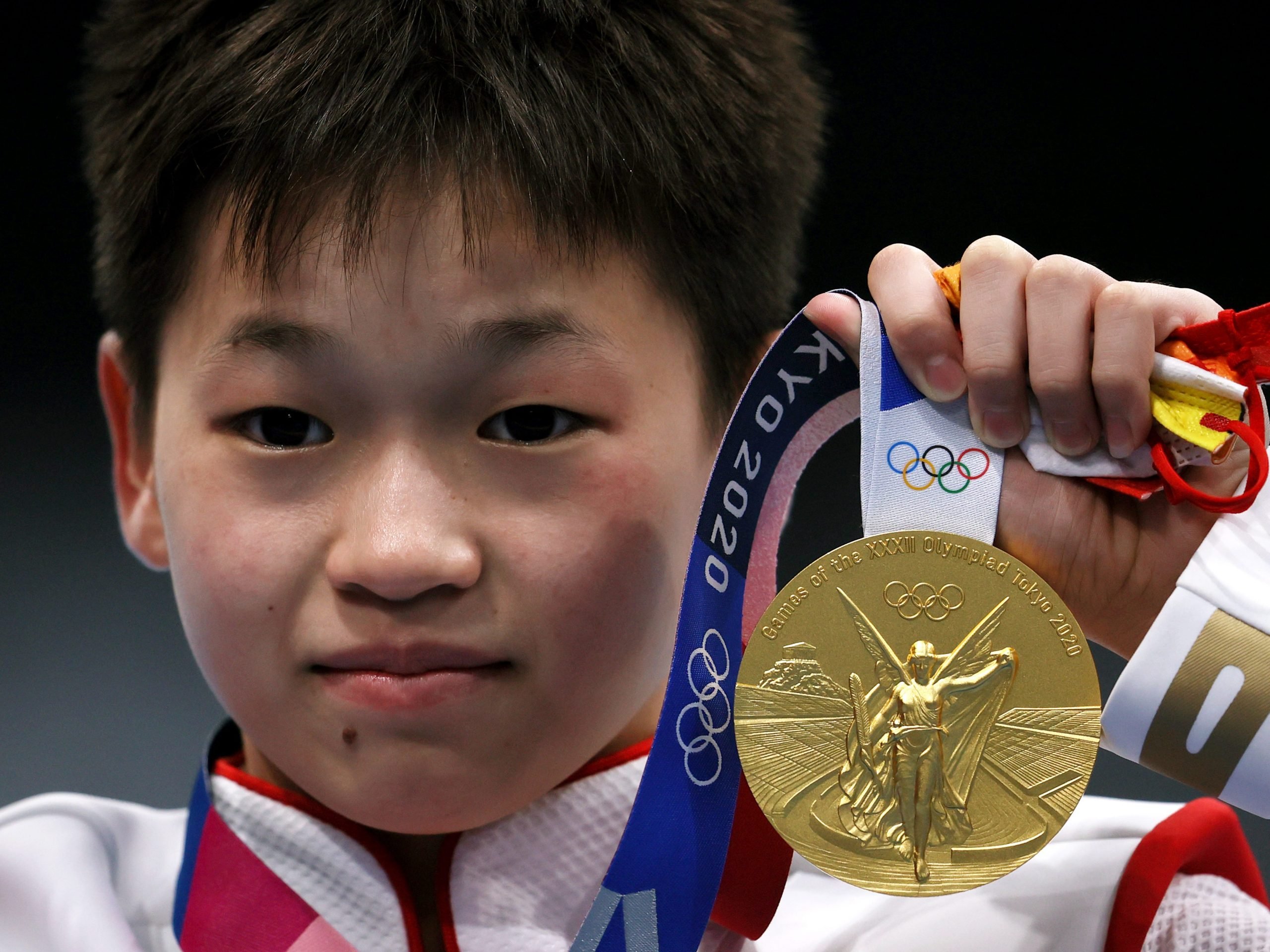 Gold medalist Hongchan Quan of Team China celebrates during the medal ceremony for the women's 10 meter platform final