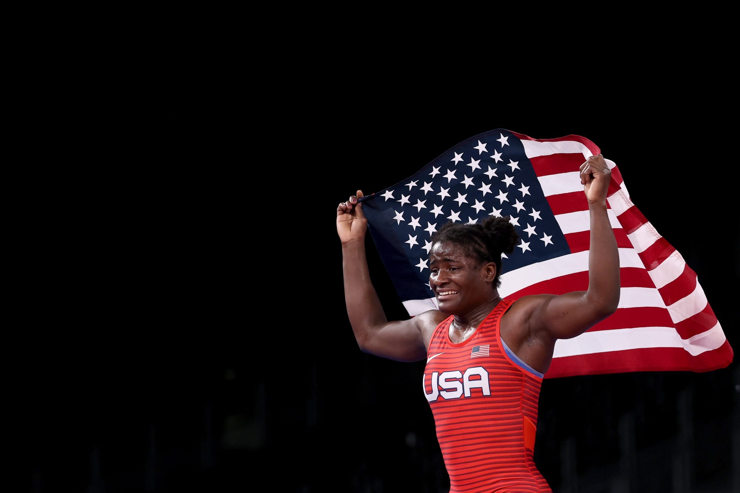Tamyra Mensah-Stock carries the American flag above her shoulders after beating her opponent to win gold at the Tokyo Olympics on Tuesday.