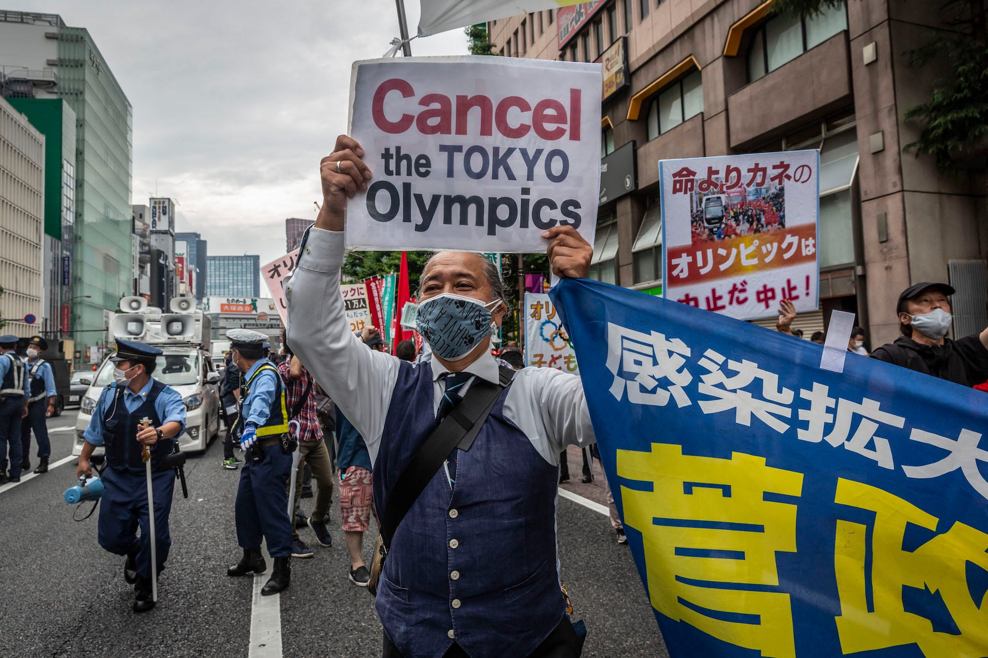 A protester holds a placard during a demonstration against the forthcoming Tokyo Olympic Games