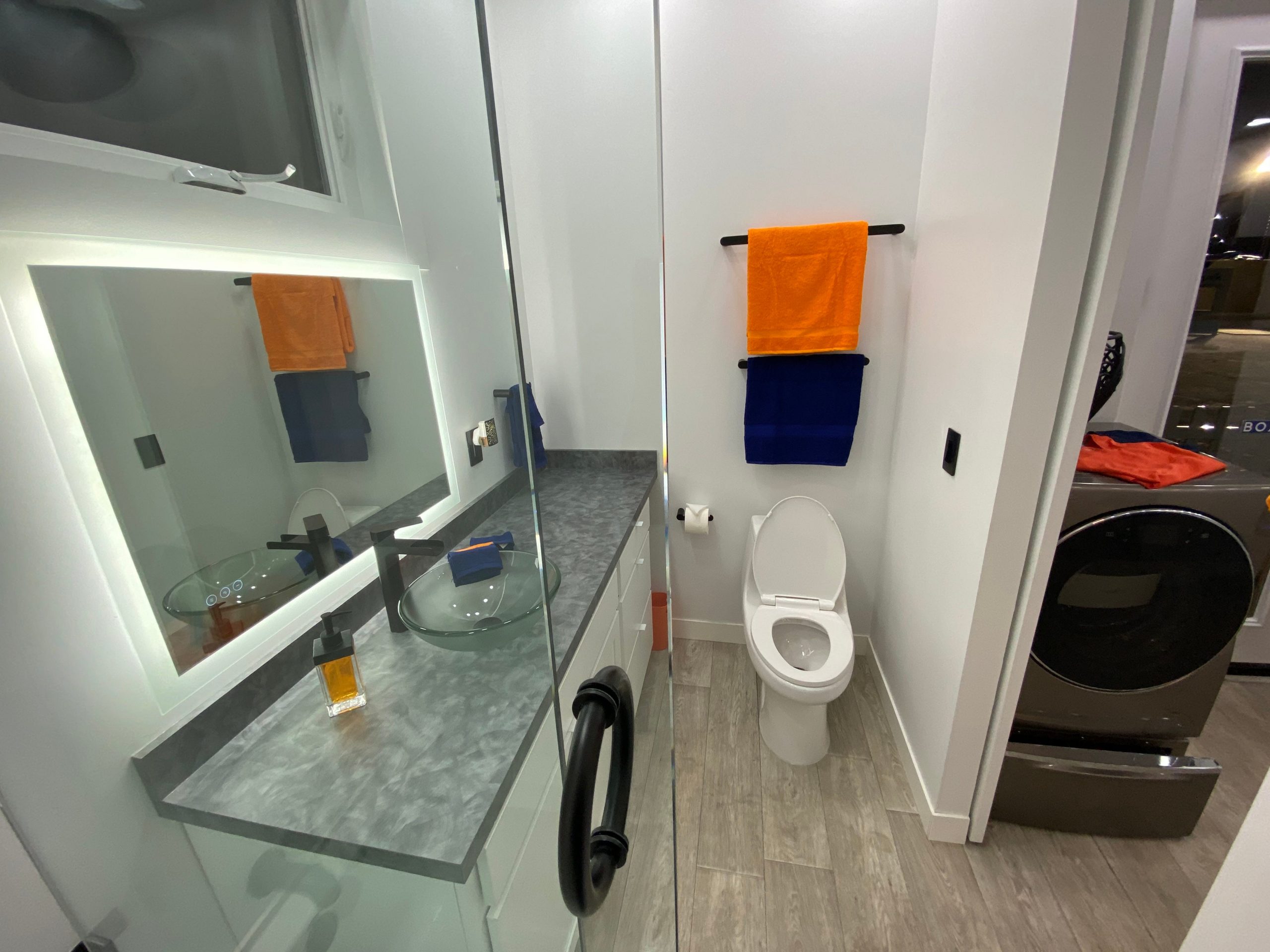 the bathroom with a toilet, sink, mirror