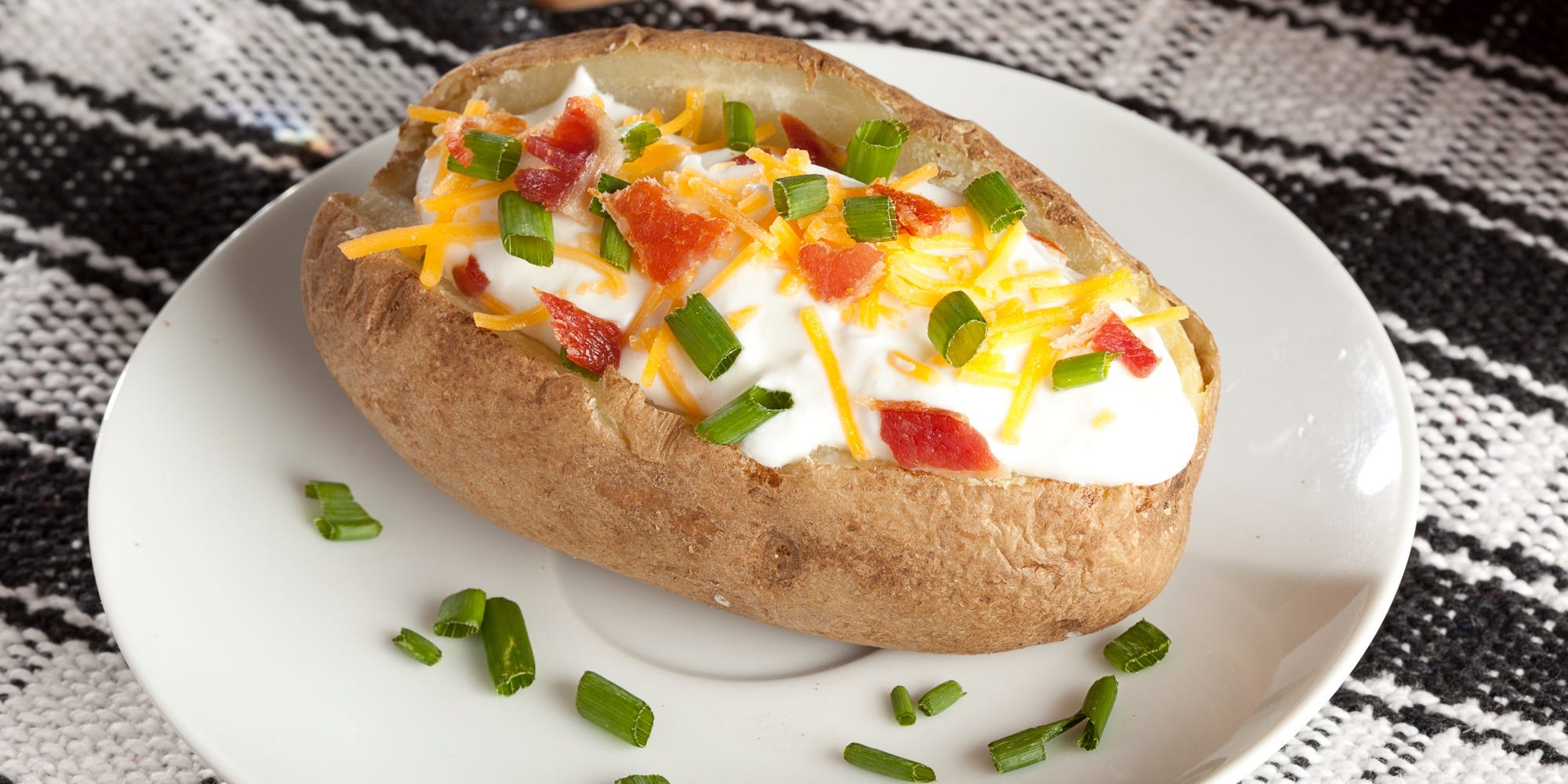 Baked potato topped with chives, cheese, and sour cheese.