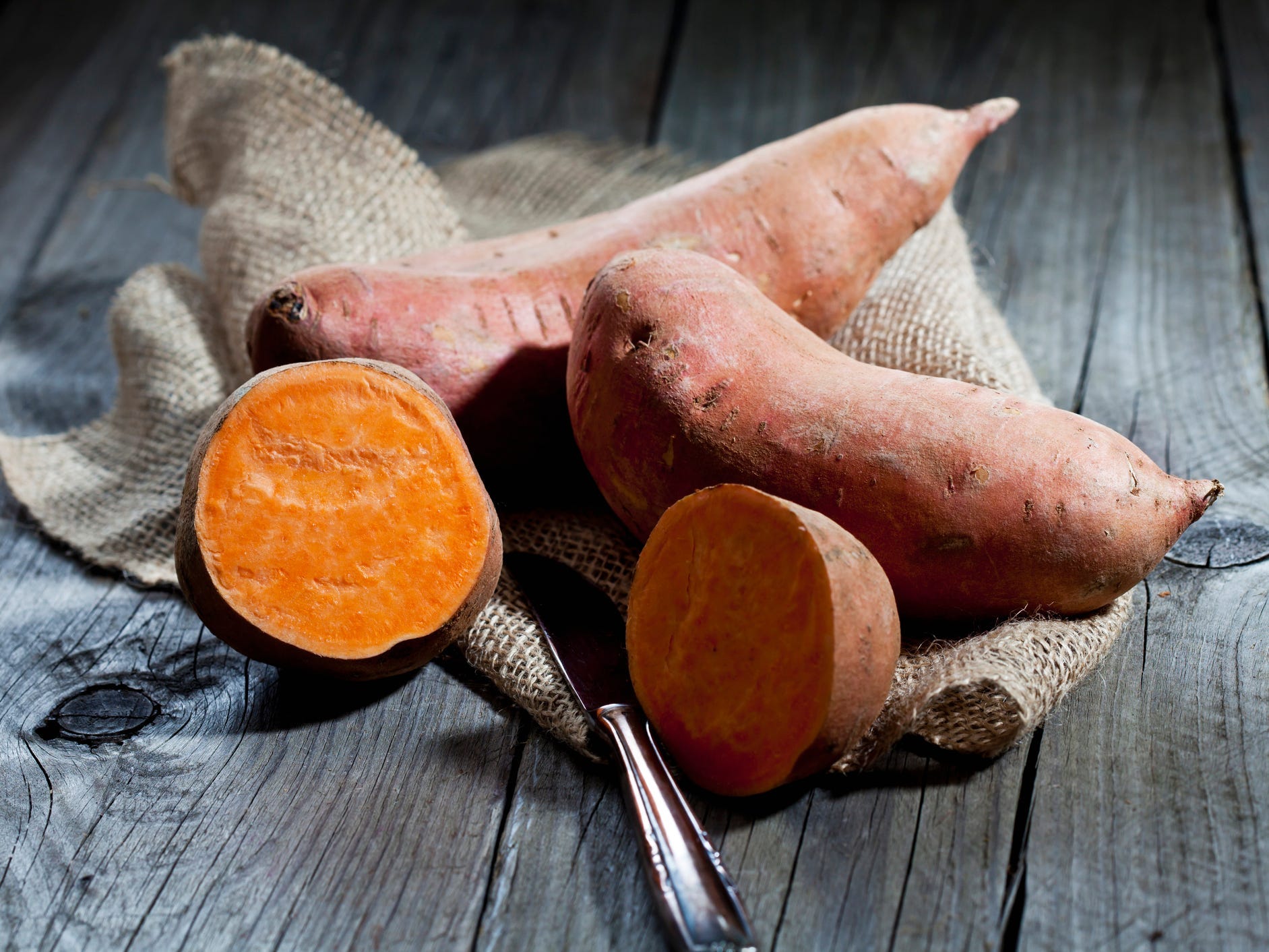 Sweet potatoes sitting on top of burlap.