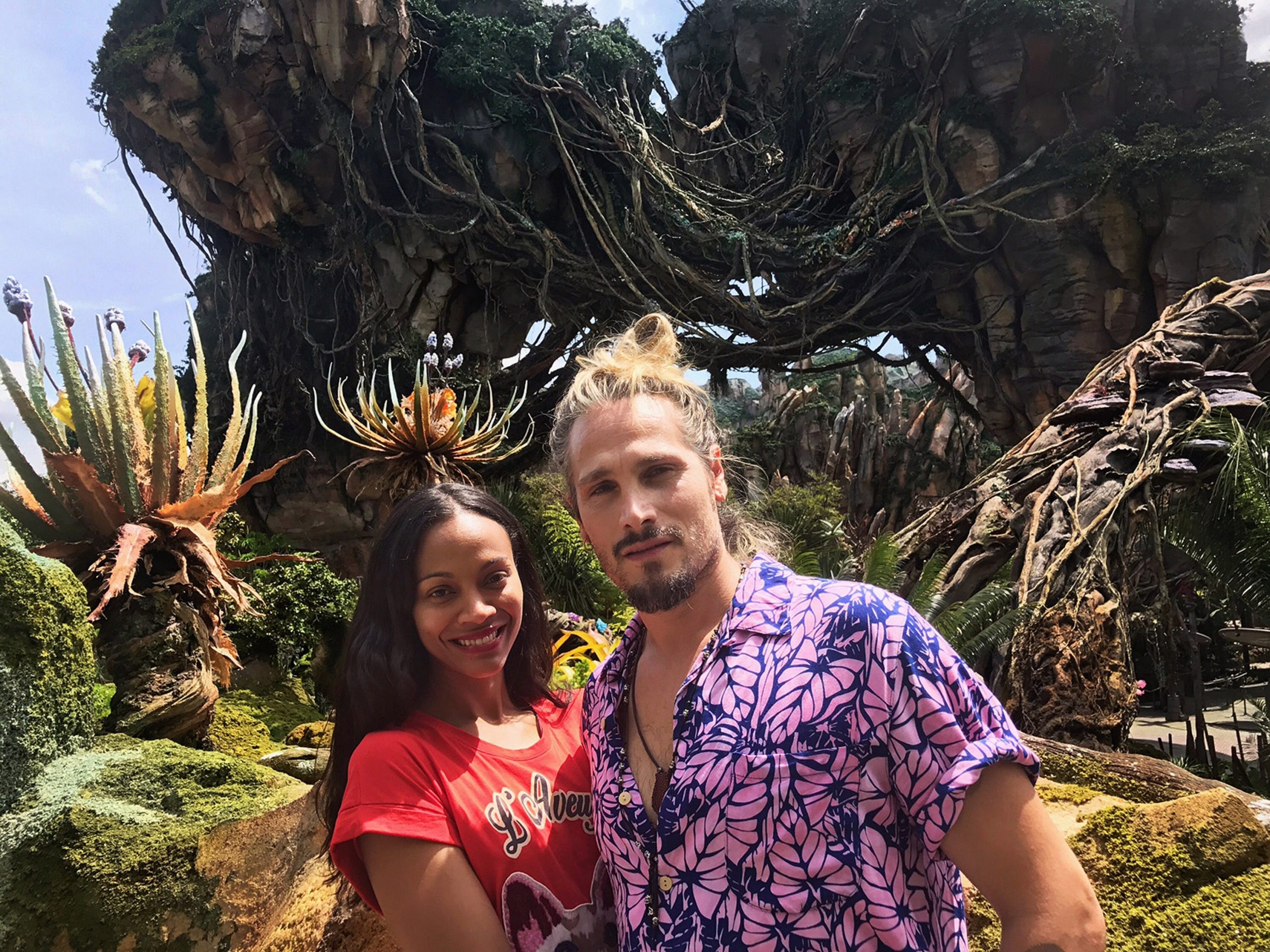 A couple stands in front of the Pandora: World of Avatar attraction at Disney World.