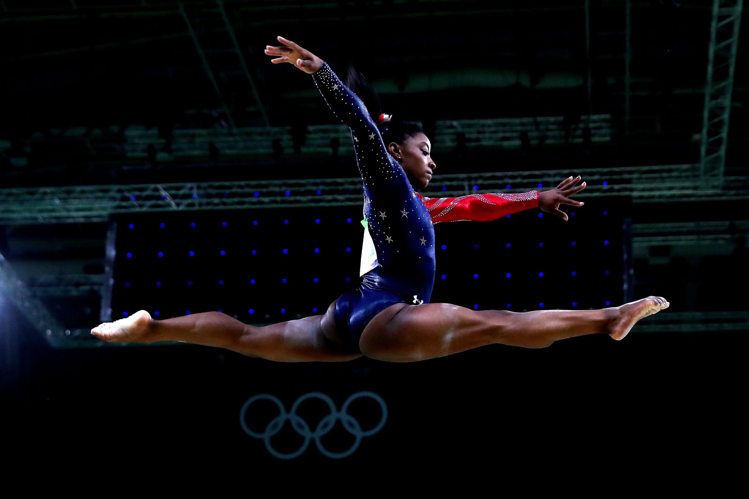 Simone Biles doing a split leap.