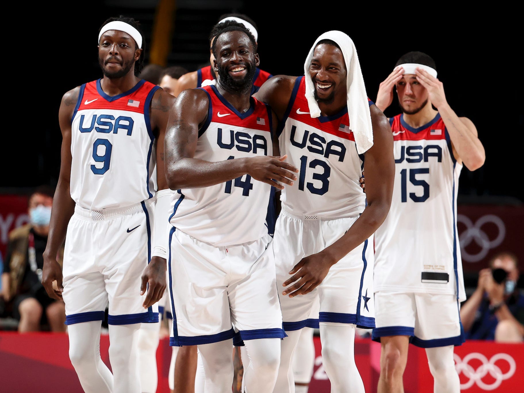 Jerami Grant, Draymond Green, Bam Adebayo, and Devin Booker smile on the court during the Tokyo Olympics.