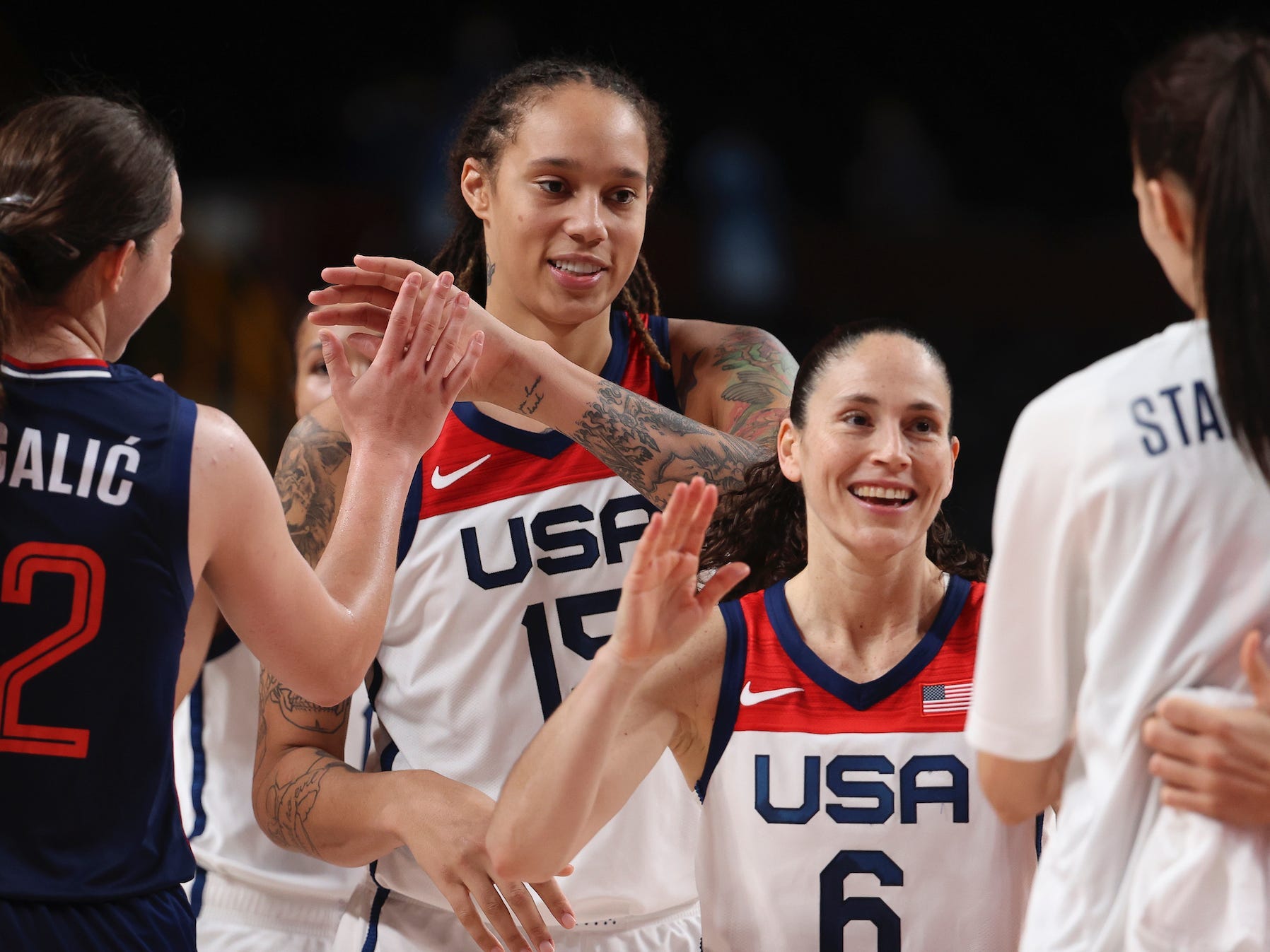 Britney Griner and Sue Bird high-five teammates at the Tokyo Olympics.