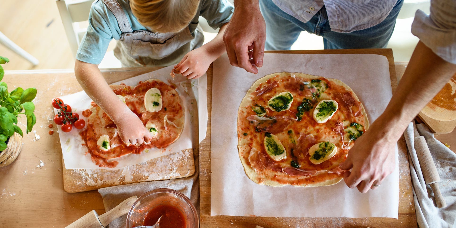 Parent and child making pizza.