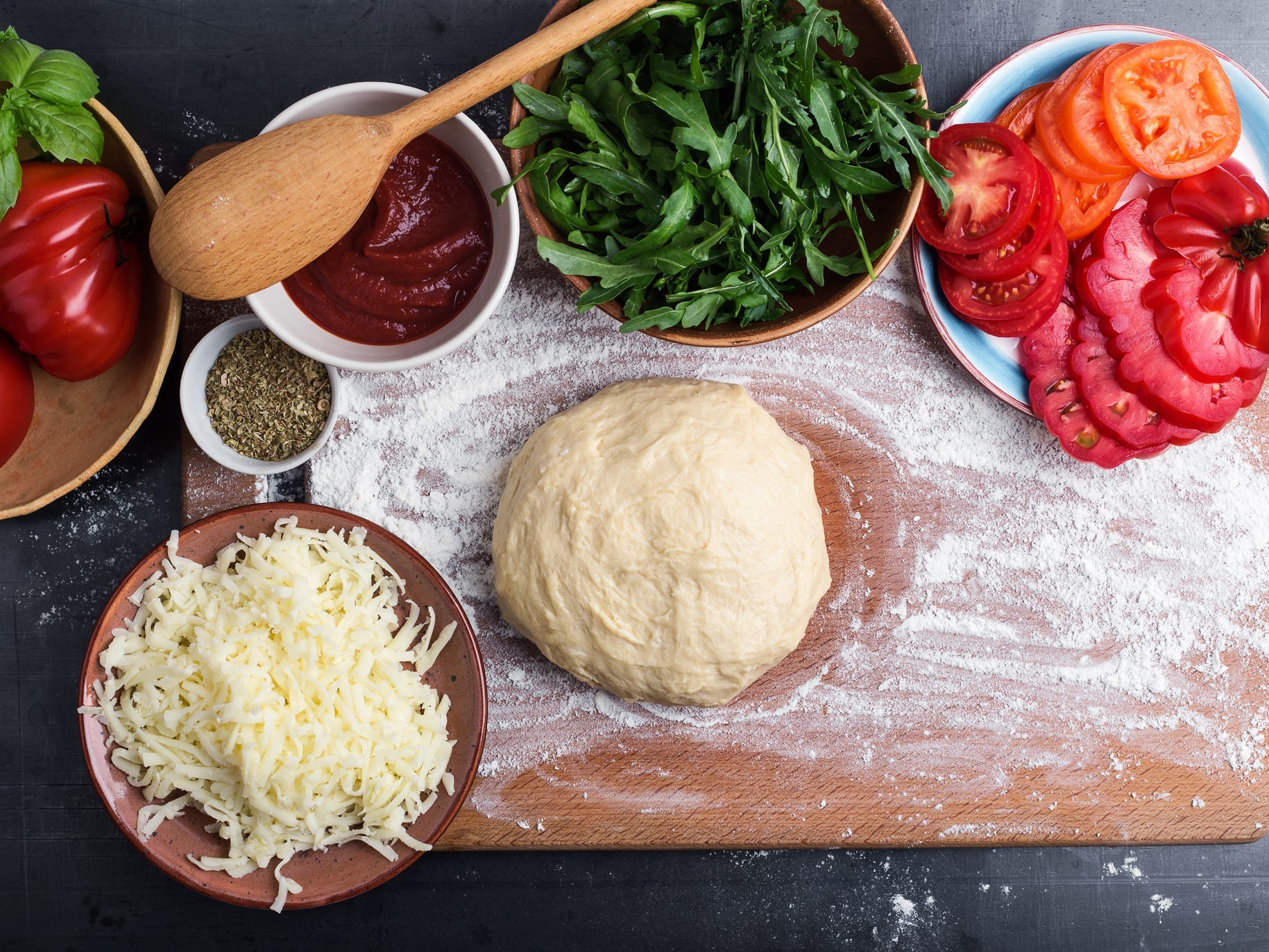 Ingredients for a pizza on a countertop.