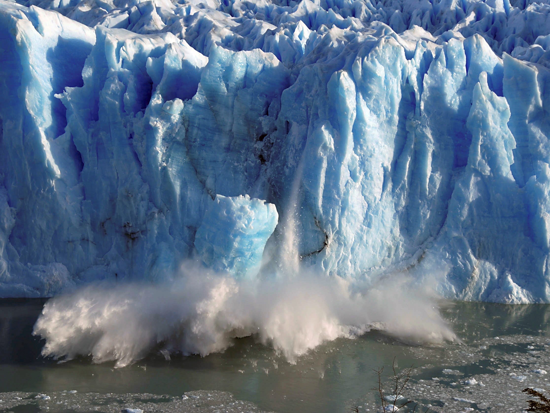 glacier calving splinters of ice fall into ocean